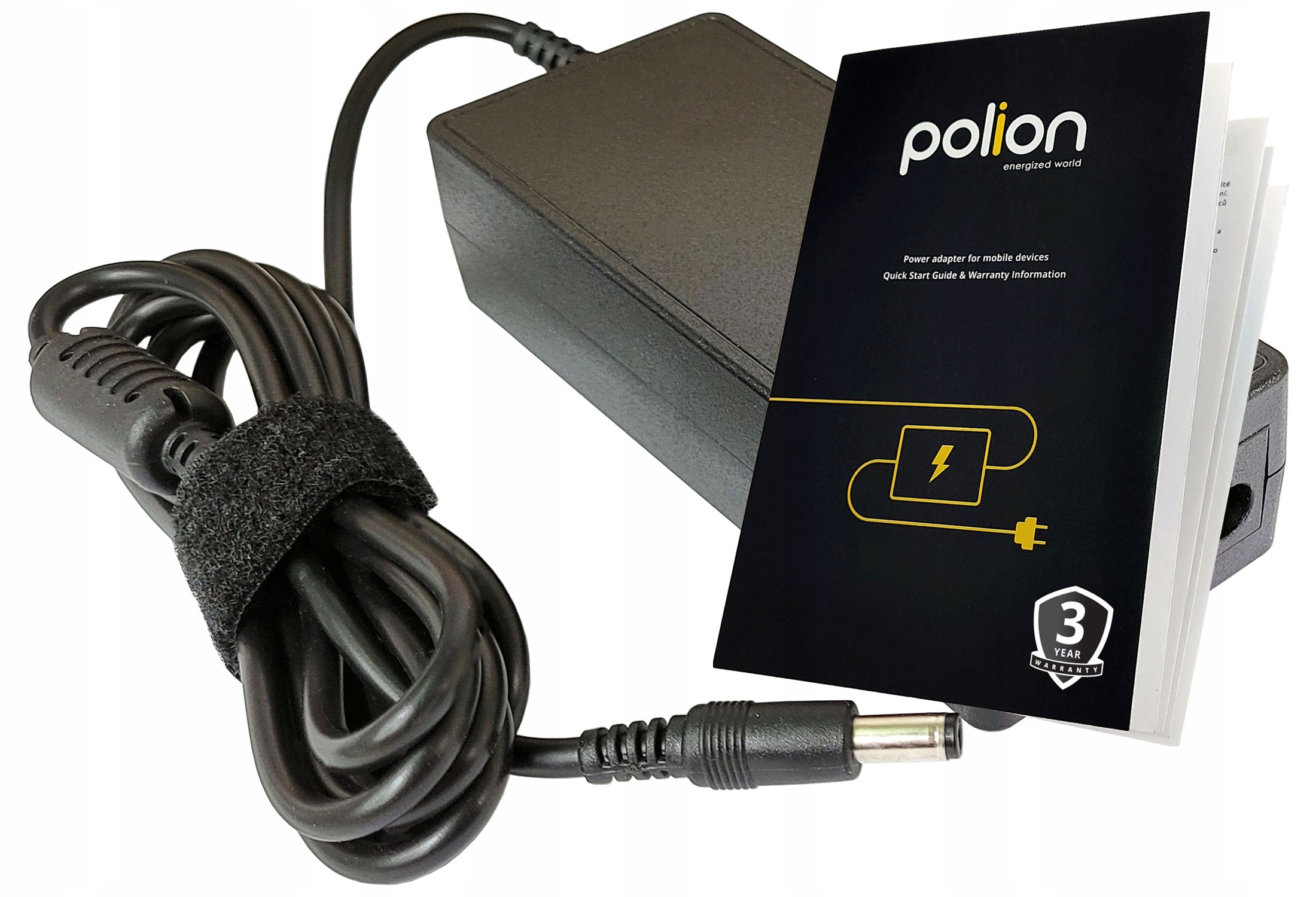 Czarny zasilacz do laptopa z kablem, instrukcją i informacją gwarancyjną. Broszura ma logo i symbol błyskawicy.