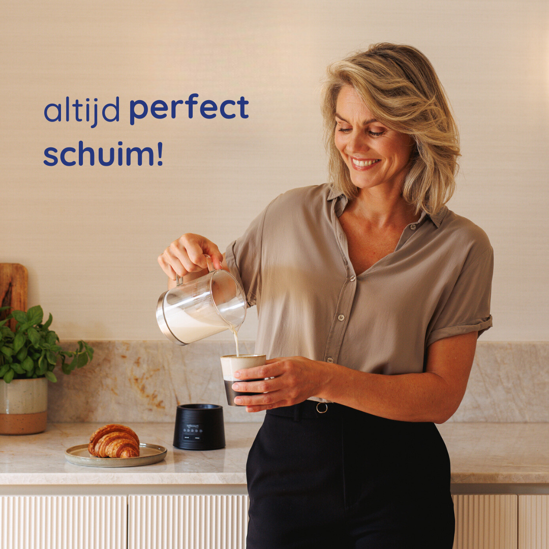 Een vrouw giet melk in een kopje. Een croissant ligt op een bord. Er staat een melkopschuimer op het aanrecht. De tekst zegt 'altijd perfect schuim'.