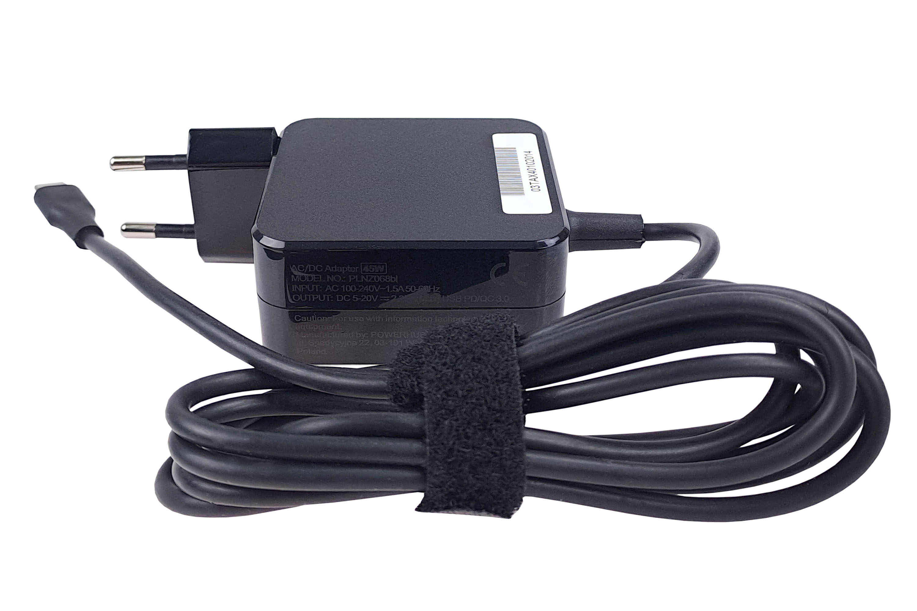 Czarny zasilacz AC/DC z przewodem zasilającym, zabezpieczony rzepem, na białym tle.