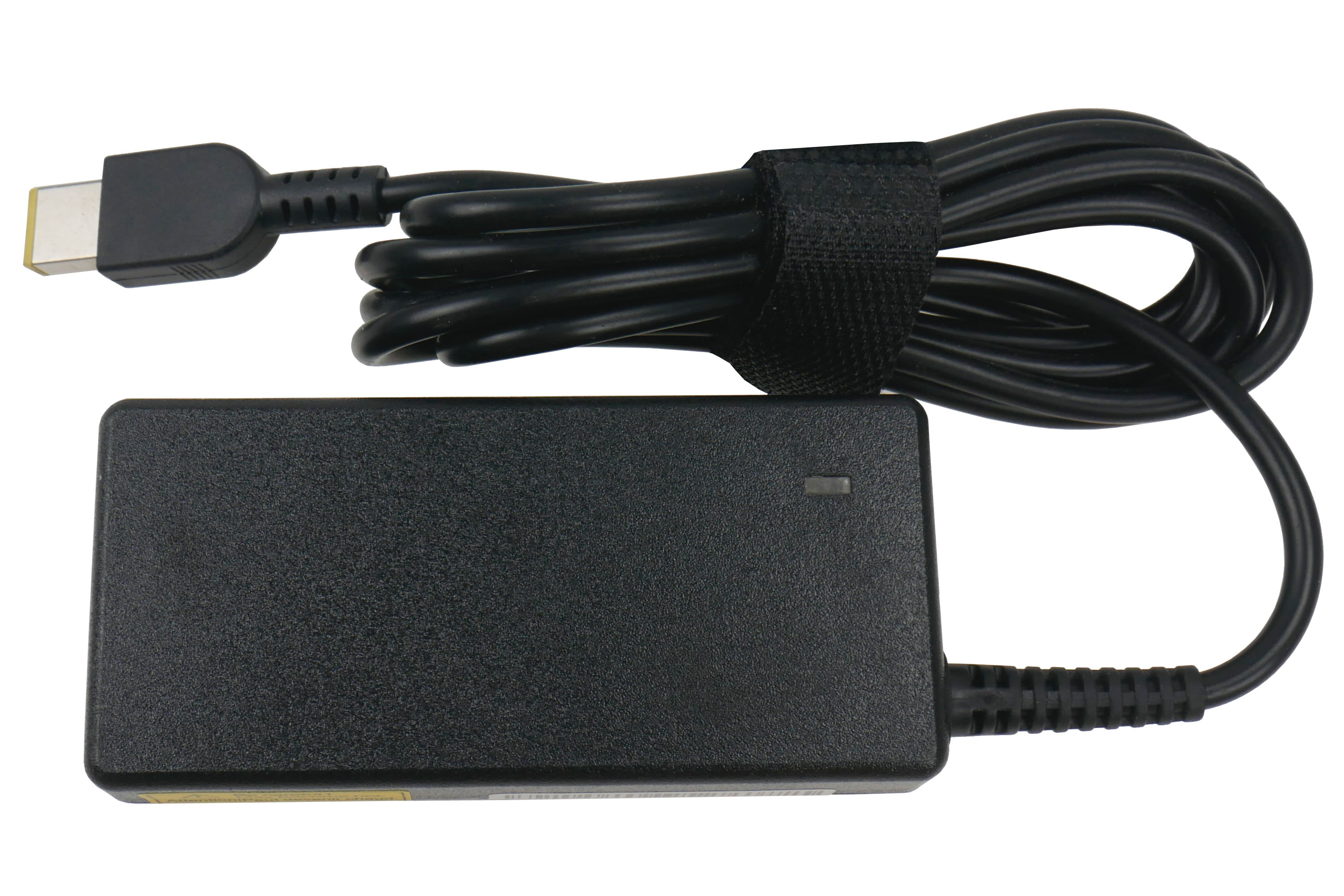 Czarna ładowarka do laptopa z czarnym kablem. Kabel jest zabezpieczony czarnym paskiem na rzep. Ładowarka ma małe światło.