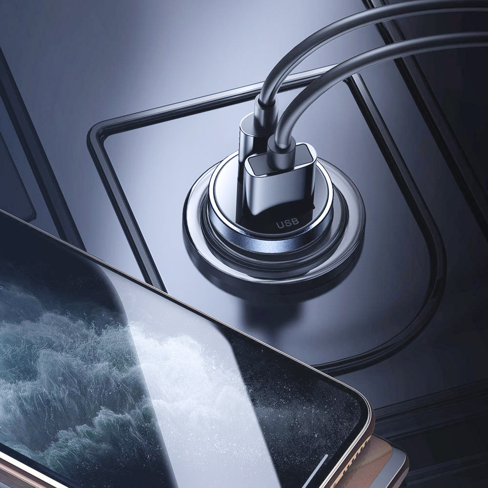 Zbliżenie stacji ładującej telefon z dwoma podłączonymi kablami USB. Smartfon jest na pierwszym planie.