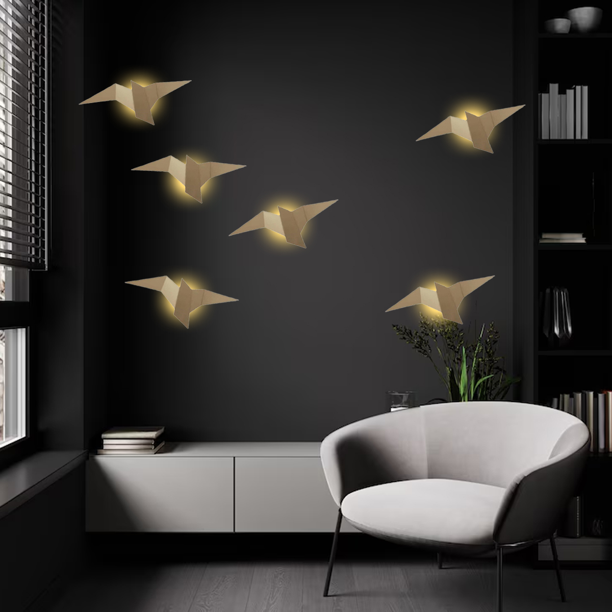 Ein modernes Zimmer mit vogelförmigen Wandleuchten. Ein weißer Stuhl steht neben einem Schrank, links ein Fenster mit Jalousien.