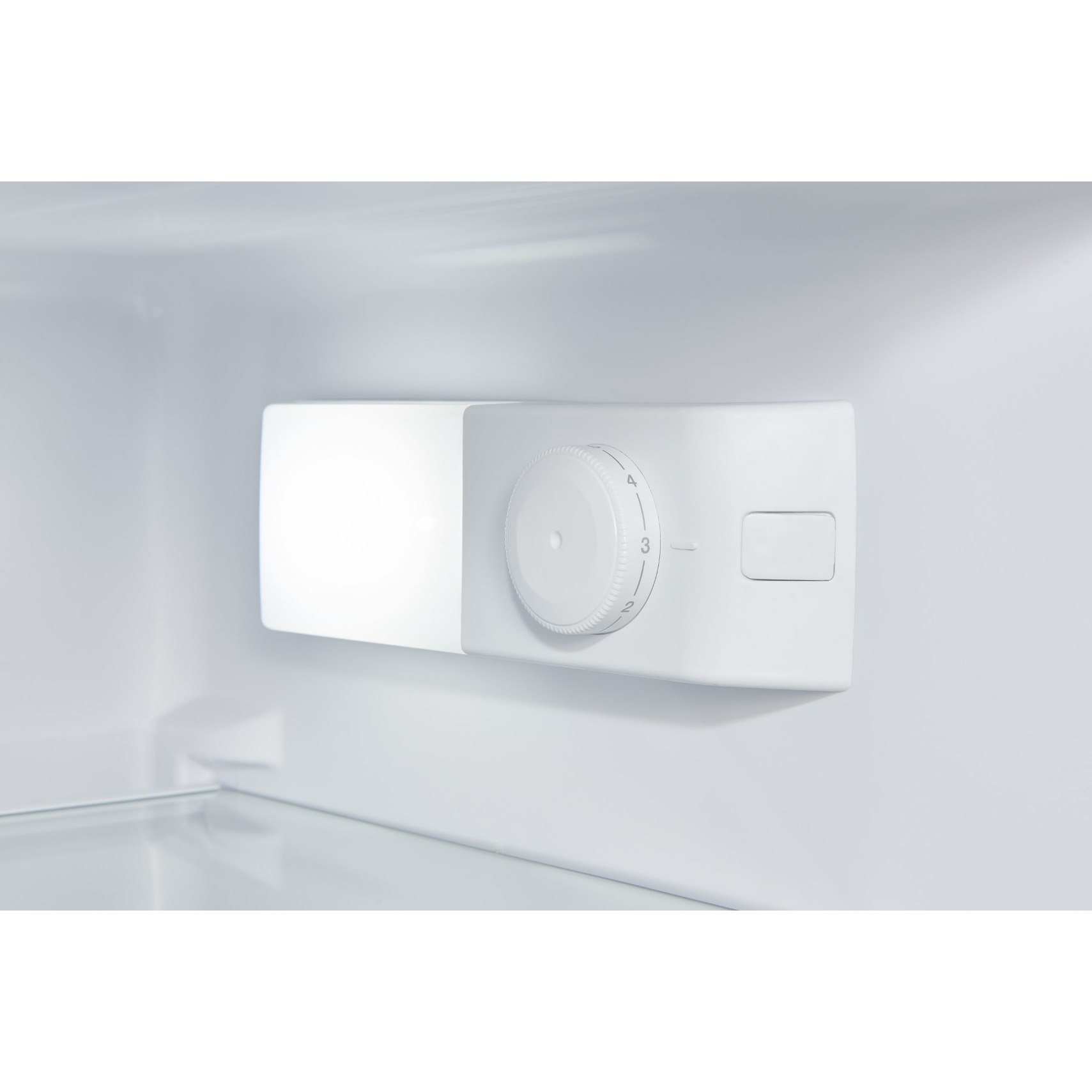 Dentro de un refrigerador blanco, un panel de control blanco con un dial ajustado en 3. Una luz brillante a la izquierda.