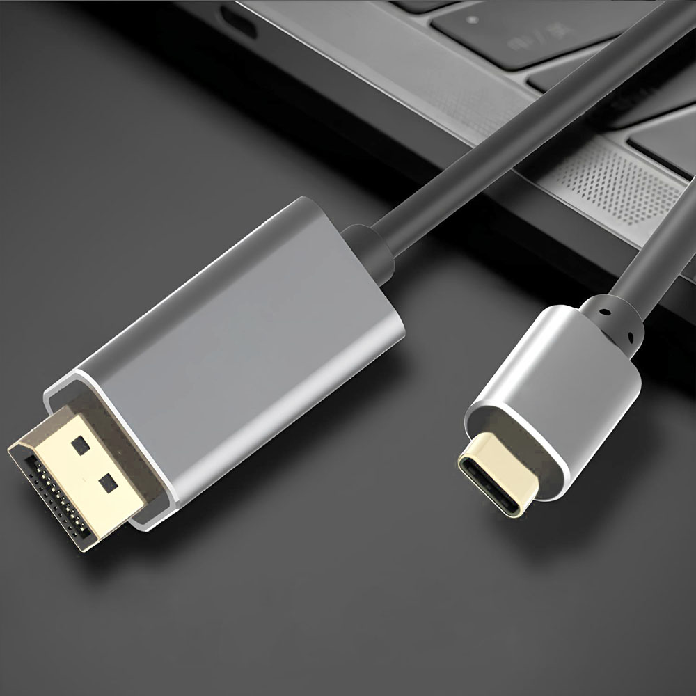 Szary kabel adaptera z złączem DisplayPort i złączem USB-C. Kabel leży na czarnej powierzchni obok laptopa.