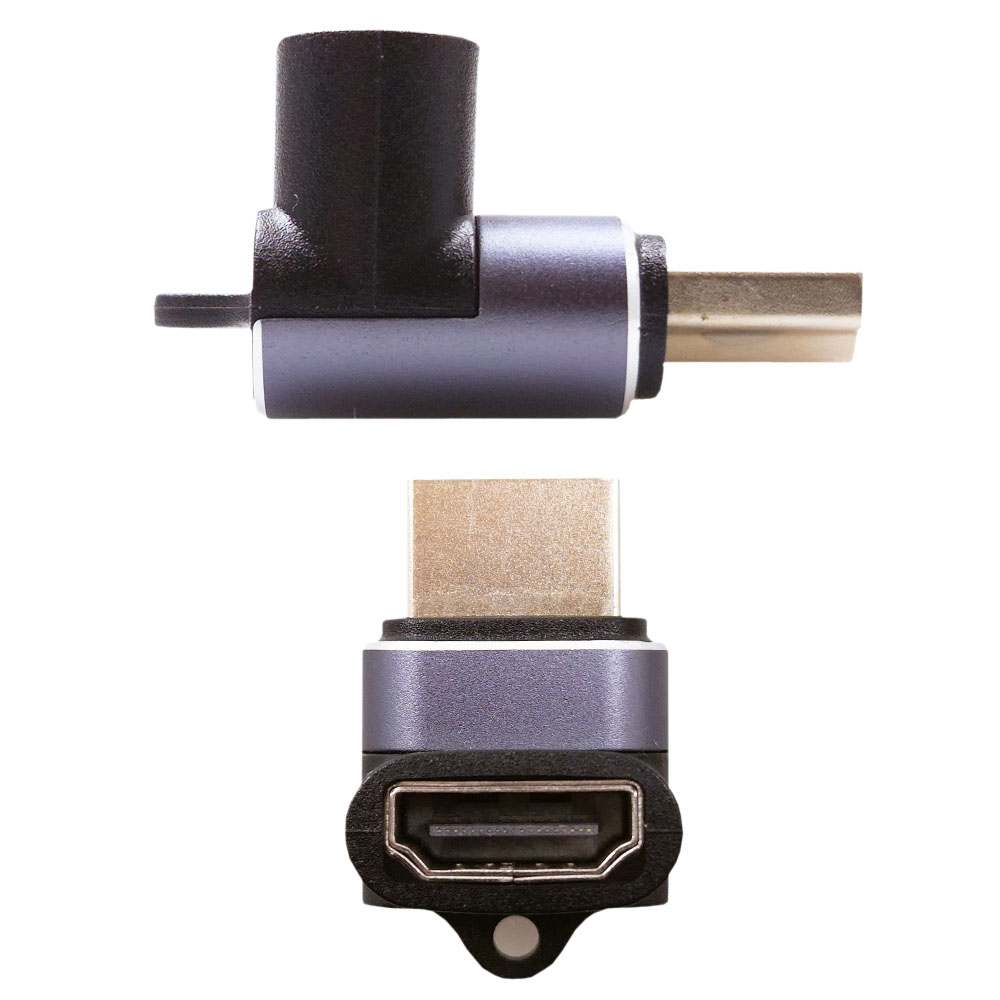 Dwa adaptery HDMI, jeden w kształcie litery L, drugi prosty. Oba mają szare i czarne części ze złotymi złączami. Białe tło.