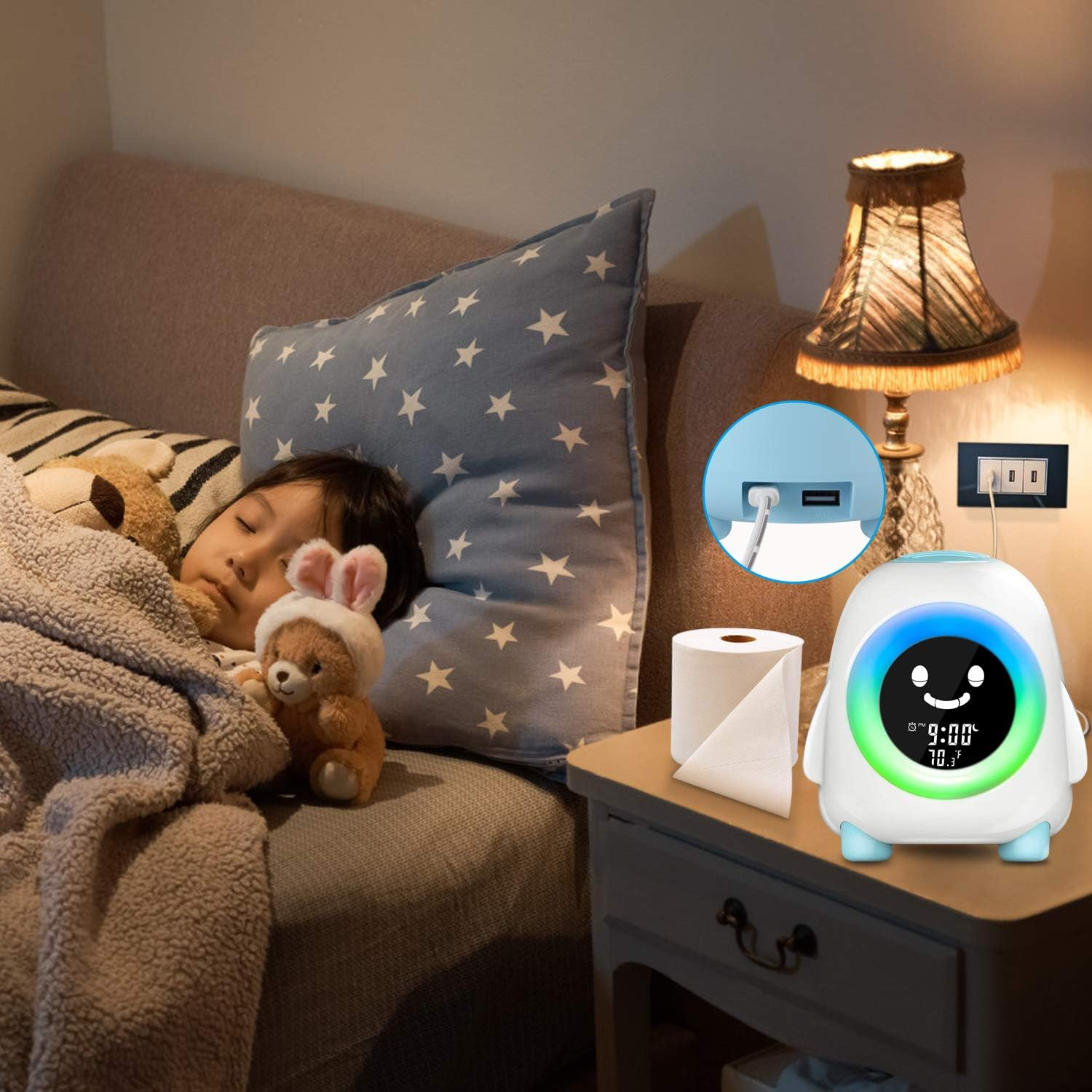 Ein Kind schläft auf einem Sofa mit einem Teddybären. Auf einem Nachttisch stehen eine Uhr und eine Papierrolle. Eine Lampe ist an.
