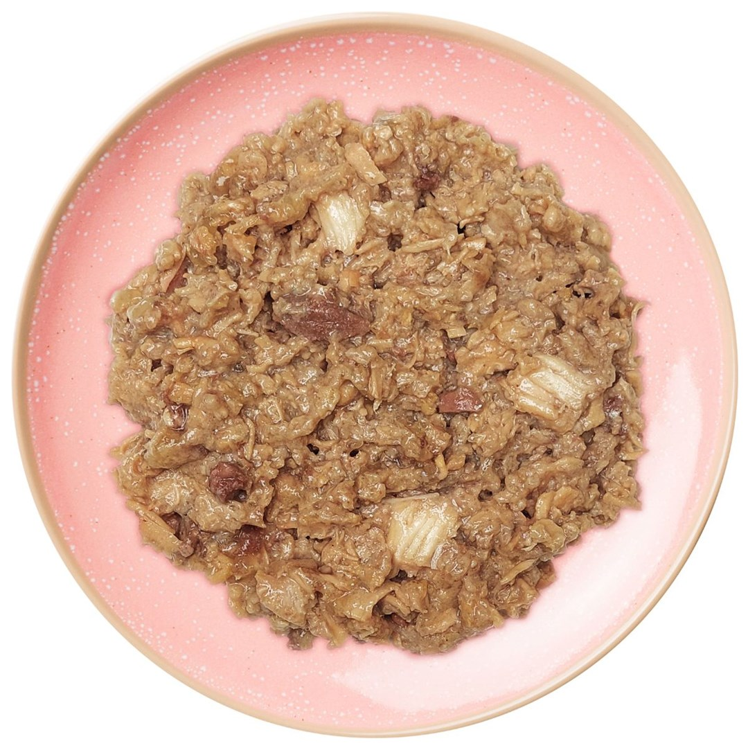 Różowy talerz zawiera porcję mokrej karmy dla kotów. Jedzenie jest brązowe i grube, z widocznymi kawałkami mięsa i warzyw.