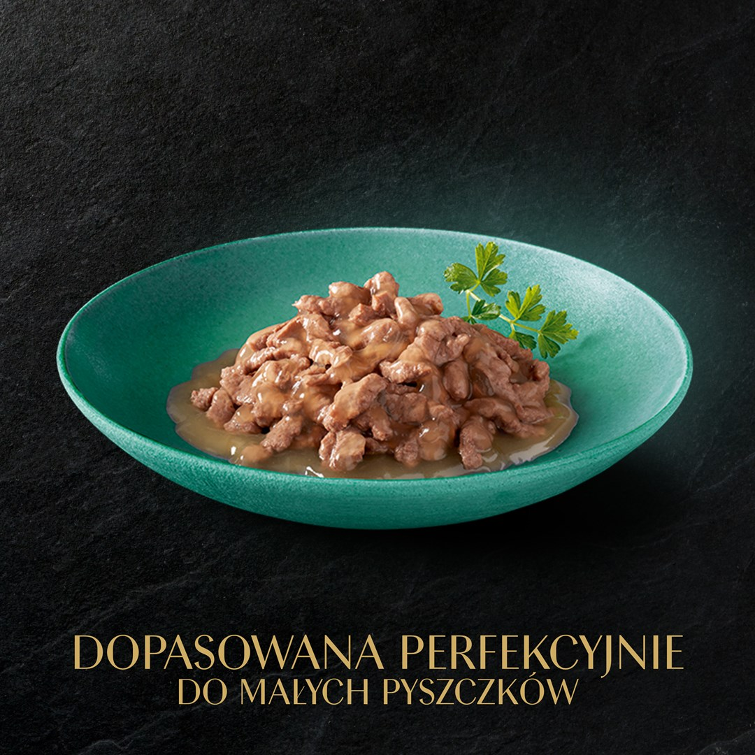 Zielona miska zawiera karmę dla kotów z kawałkami mięsa i sosem. Gałązki pietruszki zdobią jedzenie. Czarne tło z tekstem.