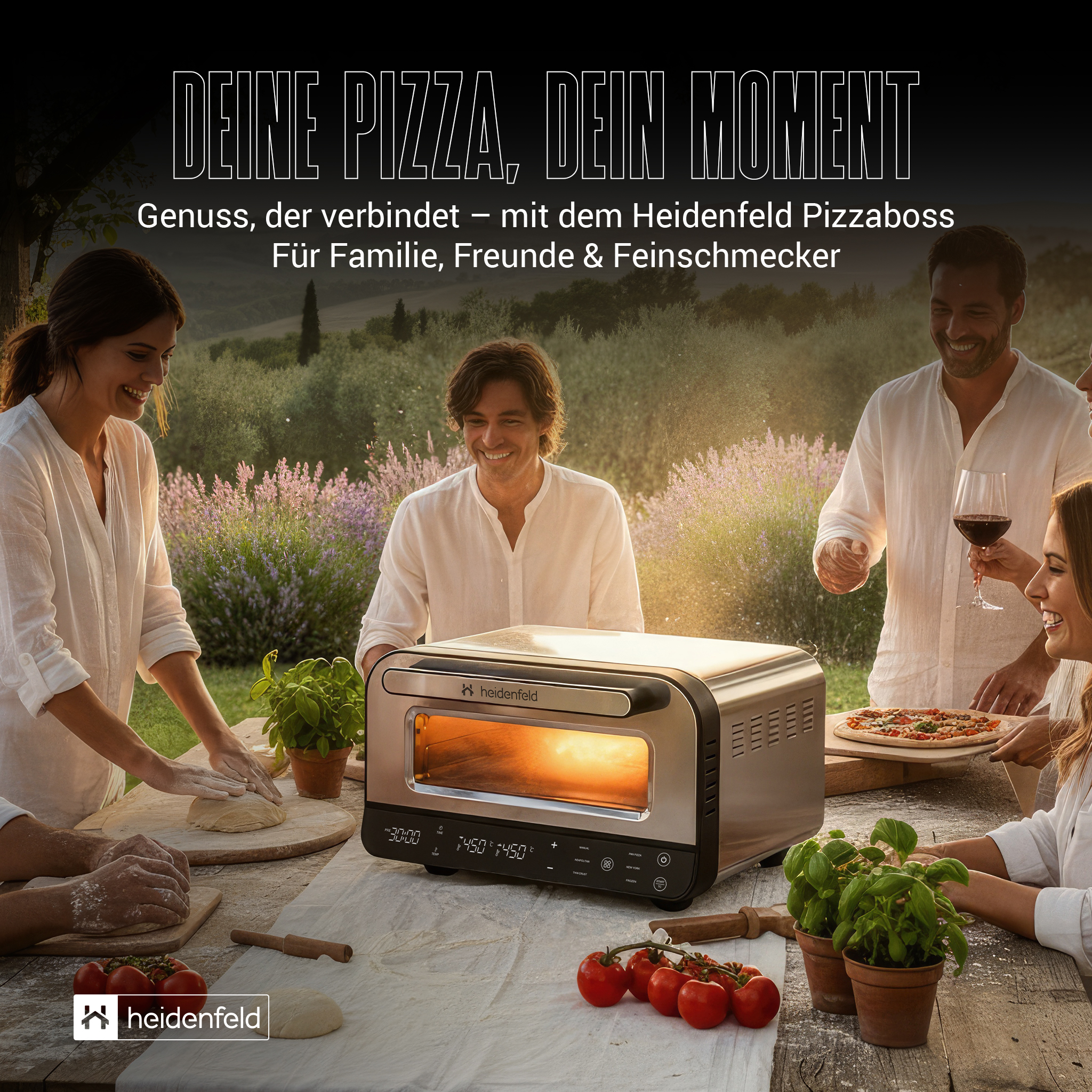 Eine Gruppe von Menschen bereitet im Freien Pizza zu und genießt sie. Ein Pizzaofen steht auf dem Tisch.