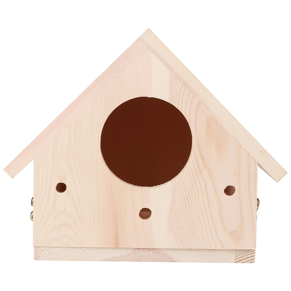 Ein hölzernes Vogelhaus mit großem kreisförmigen Eingang. Es hat ein dreieckiges Dach und mehrere kleine Löcher. Das Holz ist hell.