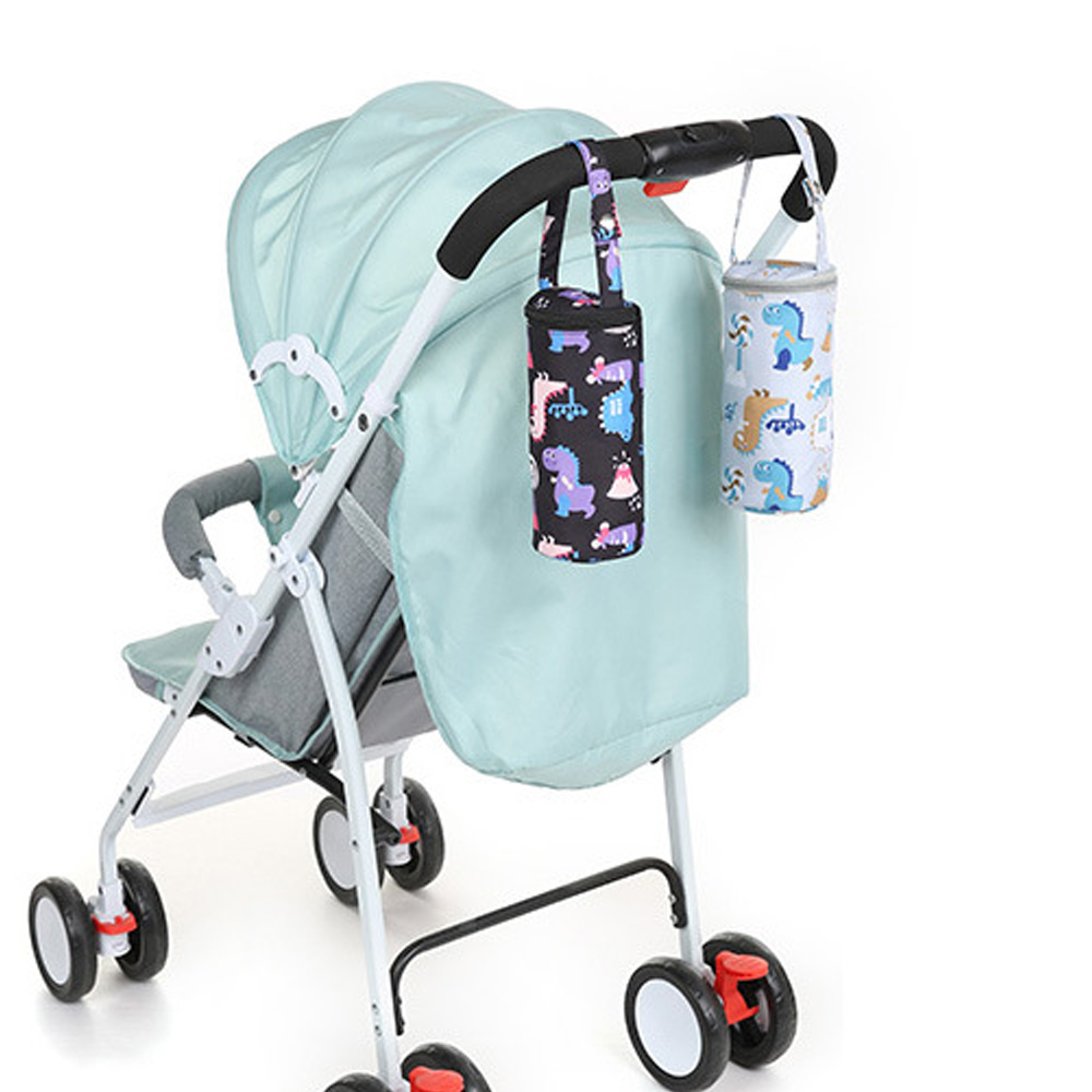Ein Kinderwagen mit zwei Flaschenhaltern. Einer ist schwarz mit Dinosauriern, der andere weiß mit blauen Dinosauriern. Beide hängen.