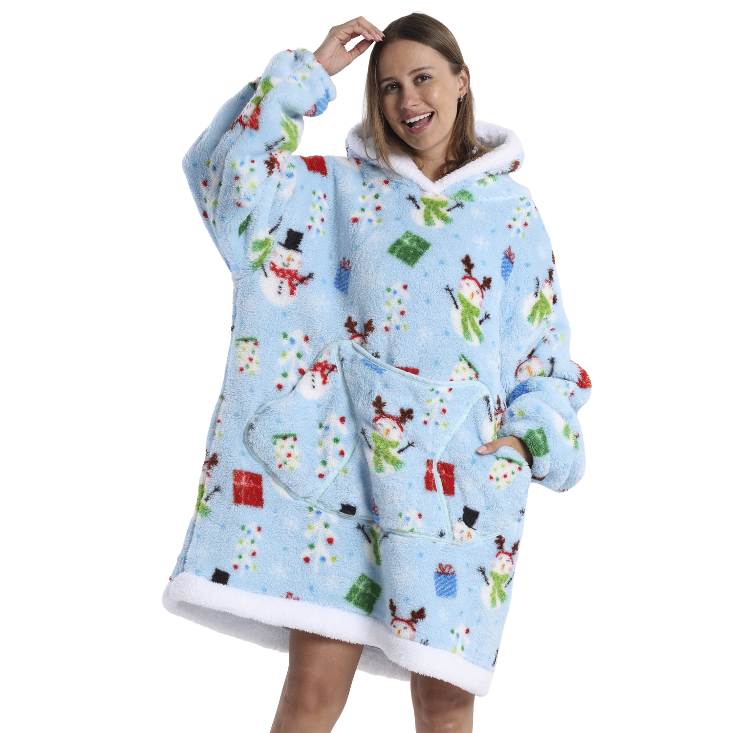 Una mujer lleva una sudadera azul navideña con muñecos de nieve y regalos. Sonríe, con la mano en la cabeza, sobre fondo blanco.