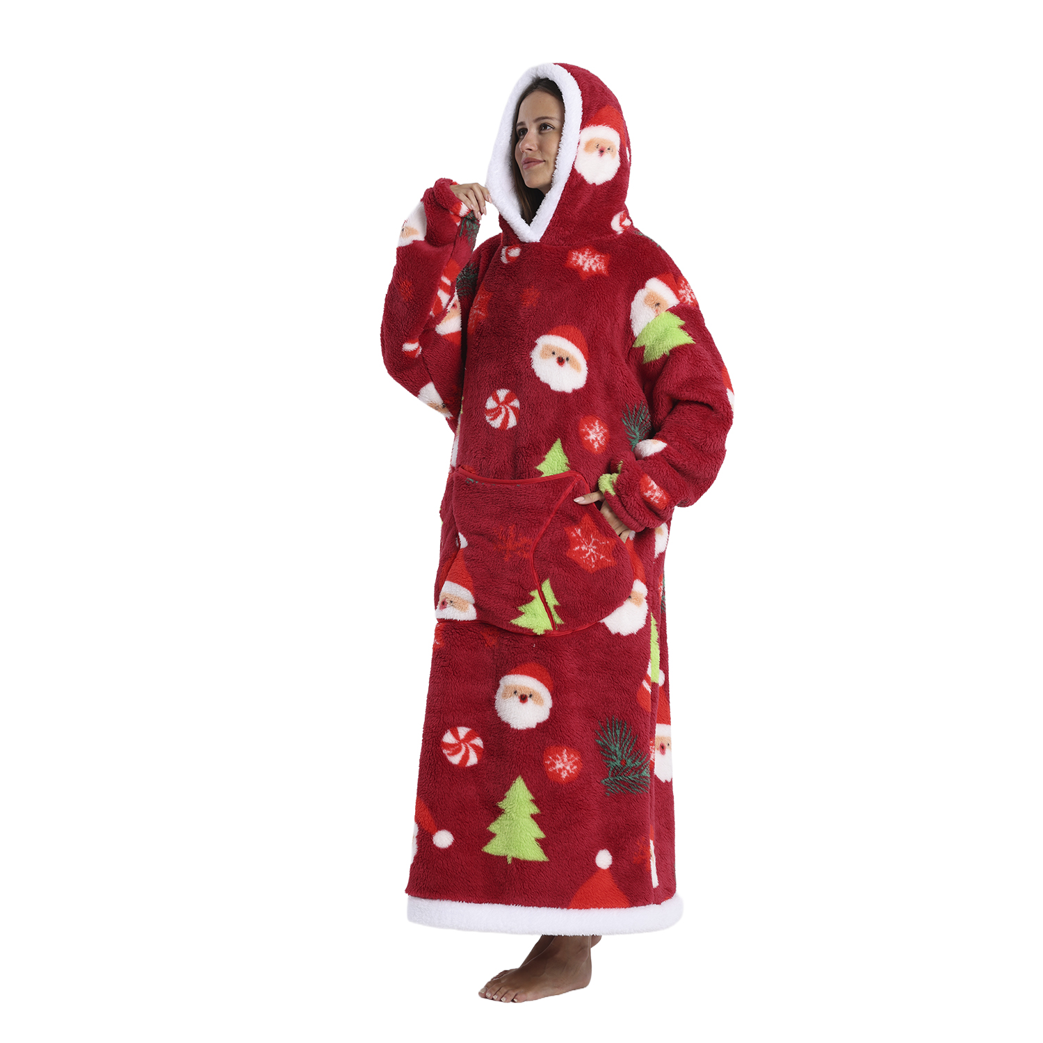 Una mujer de pie en una manta con capucha roja con temática navideña. La manta tiene patrones de Santa, árbol y bastones de caramelo. Ribete de piel blanca.