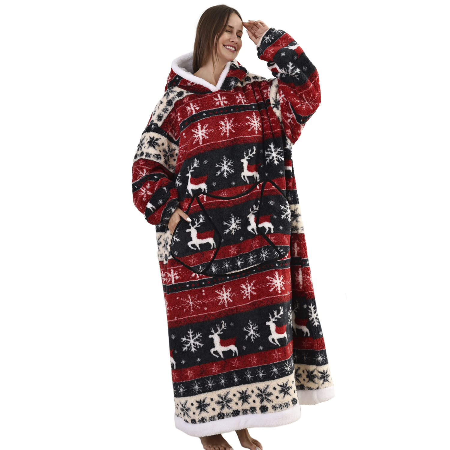 Donna in una coperta con cappuccio a fantasia rossa, nera e bianca. Il motivo include fiocchi di neve e renne. Sorride e si protegge gli occhi.