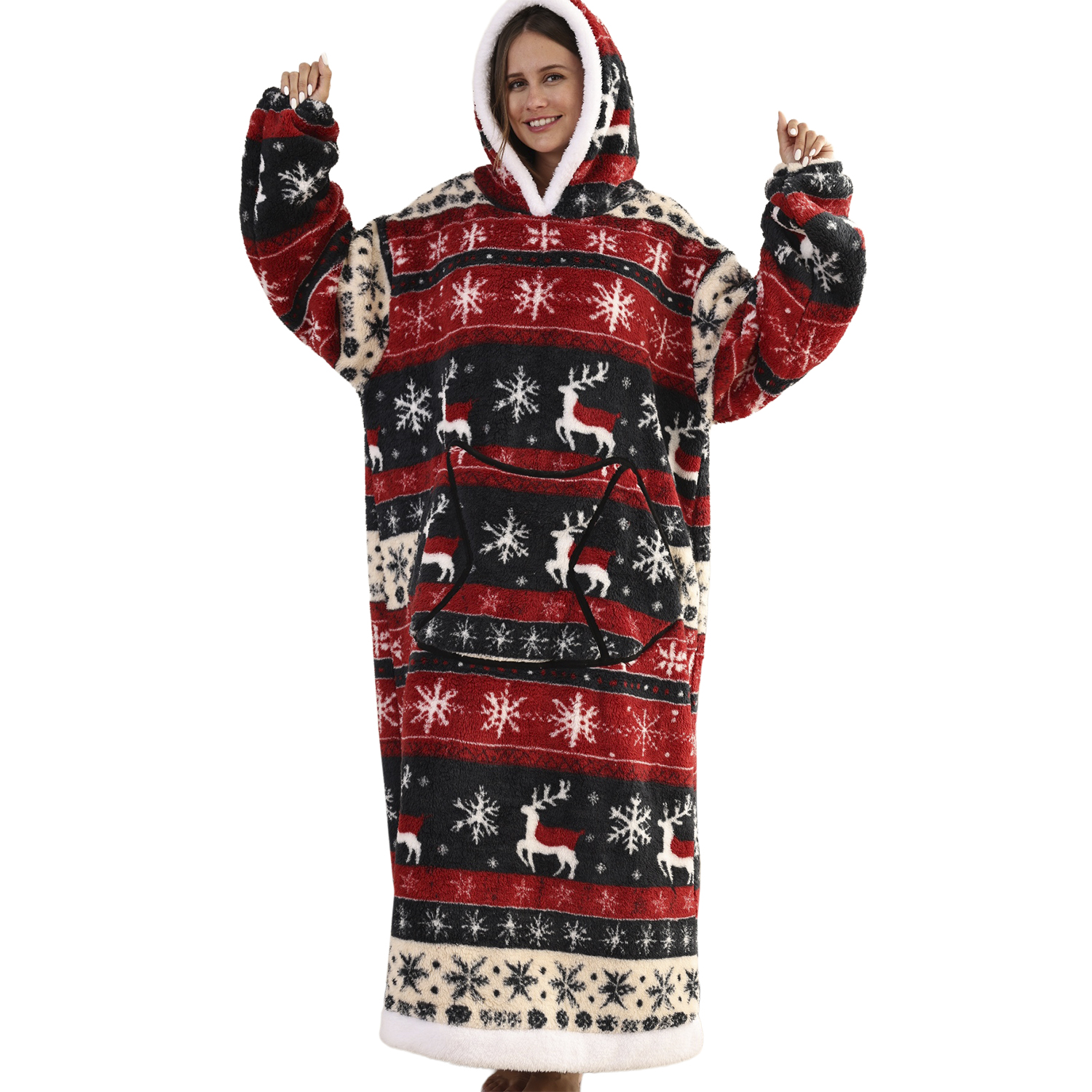 Donna con coperta con cappuccio festiva rossa, nera e bianca. La coperta ha motivi di renne e fiocchi di neve. Sorride e alza le braccia.