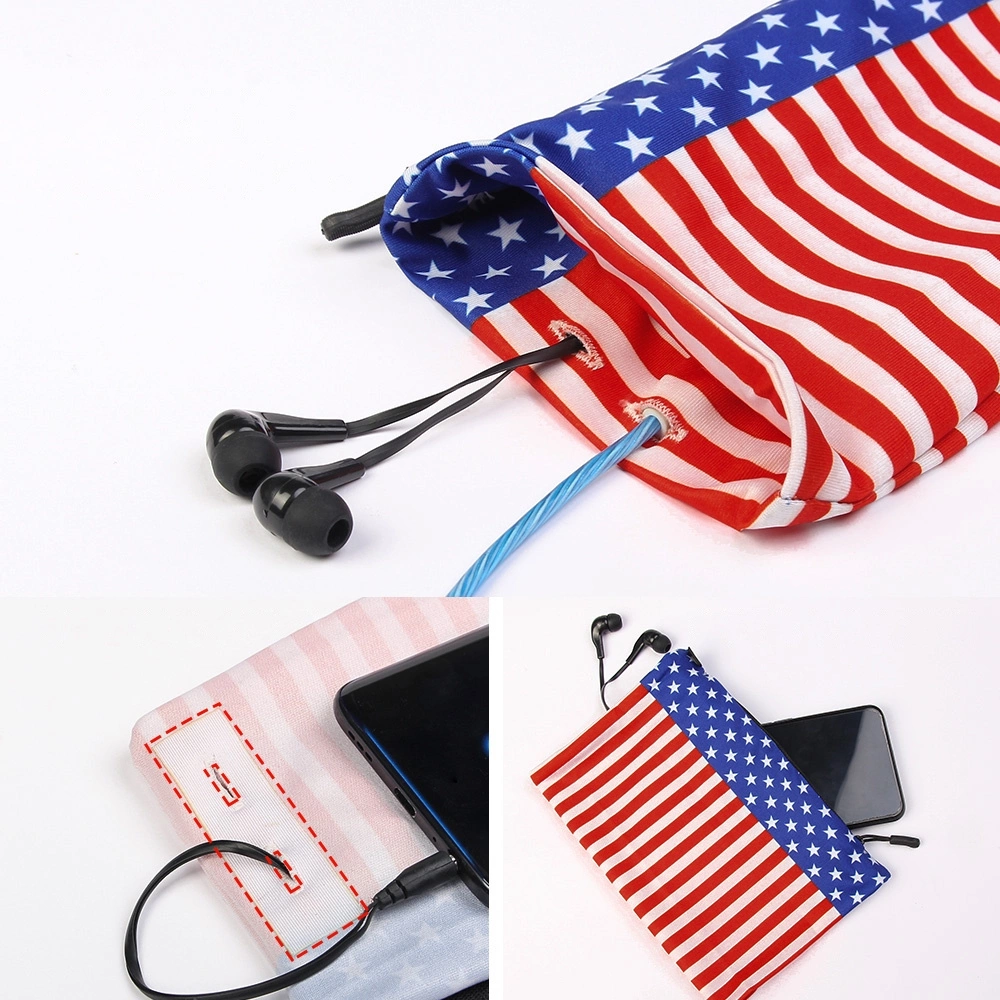 Eine Tasche mit amerikanischer Flagge, Kopfhörern und einem Telefon. Die Tasche hat rot-weiße Streifen und ein blaues Sternenfeld. Kopfhörer und Telefon sind schwarz.
