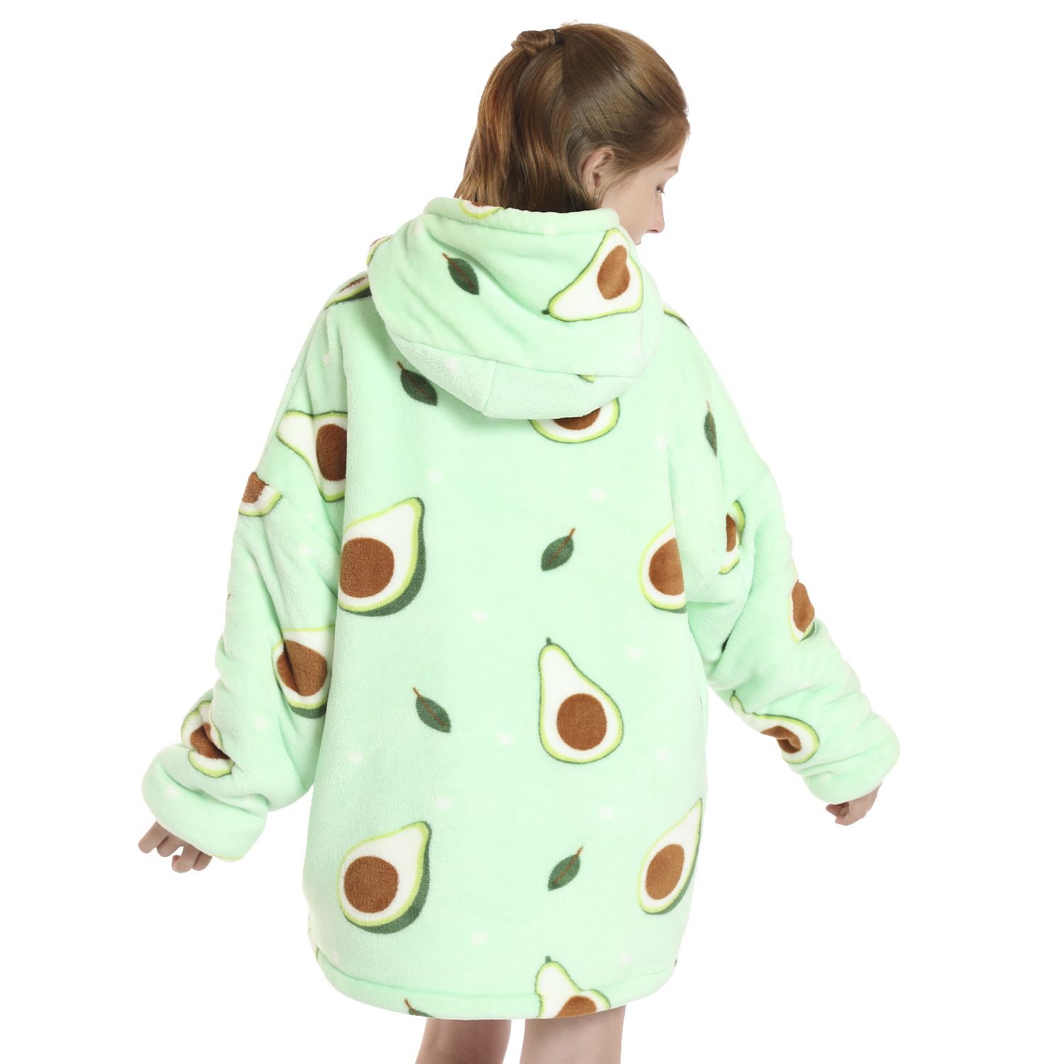 Una persona lleva una manta con capucha verde con estampado de aguacate. La persona está de espaldas a la cámara, con la capucha puesta.