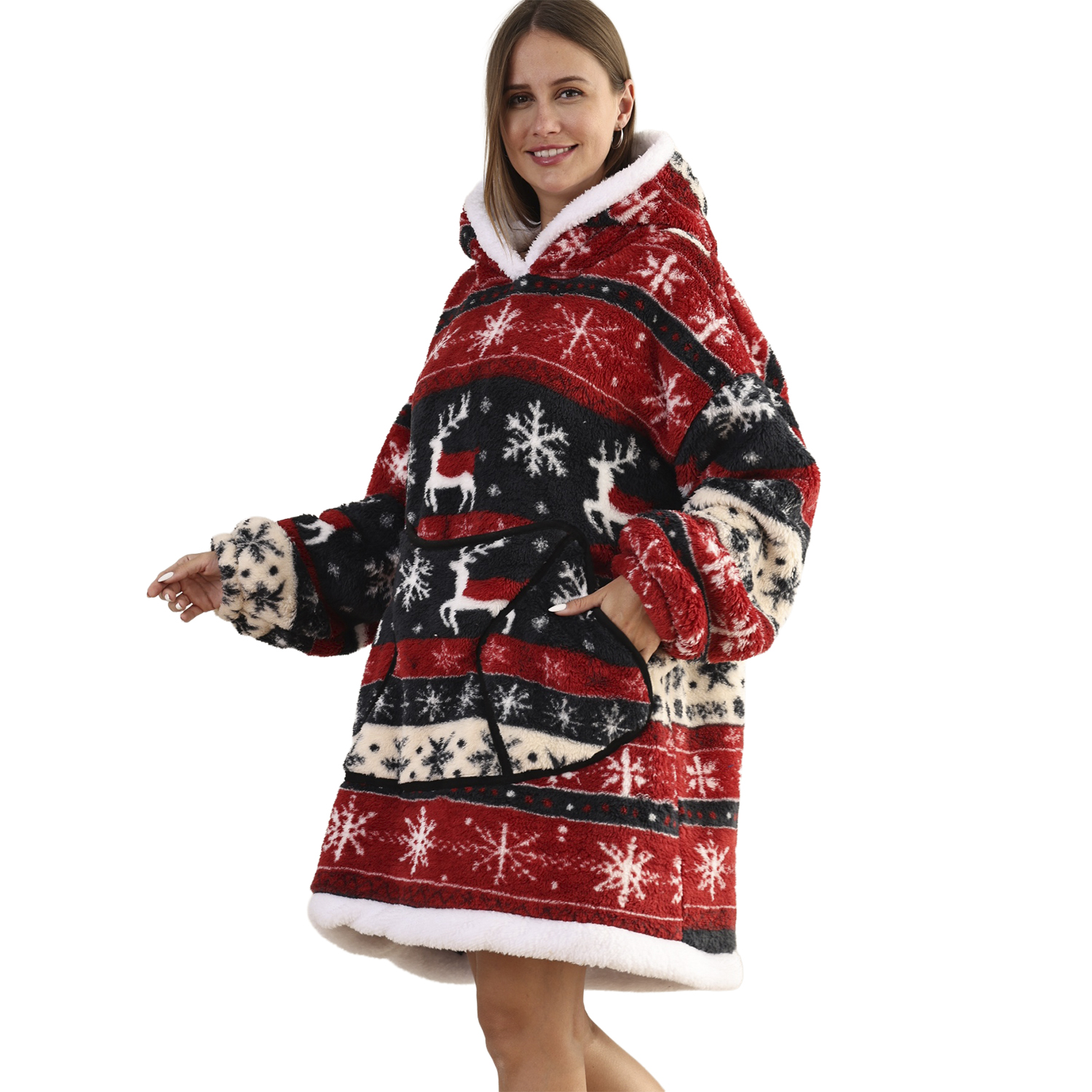 Una mujer con una sudadera navideña roja, blanca y negra con renos y copos de nieve, sonriendo, sobre fondo blanco.