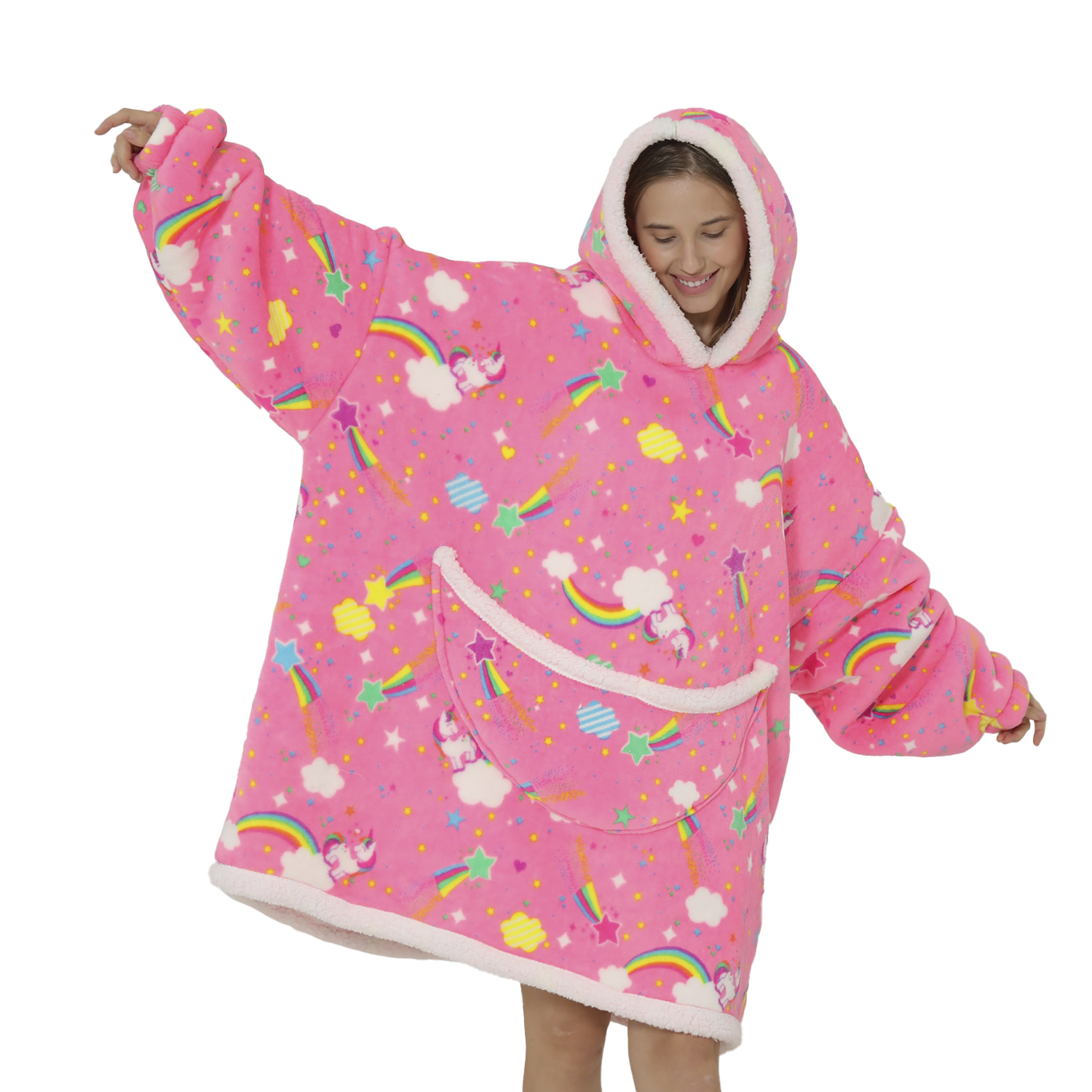 Una donna indossa una felpa con cappuccio a unicorno rosa con motivi arcobaleno e stelle. Ha le braccia tese, sorridente. Sfondo bianco.
