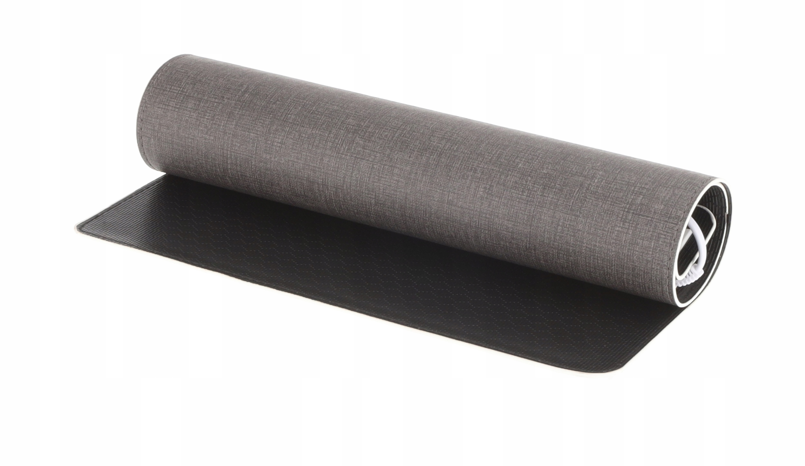 Zwinięta szara mata do jogi leży na czarnej macie. Zrolowana część ma białe krawędzie. Tło jest białe.