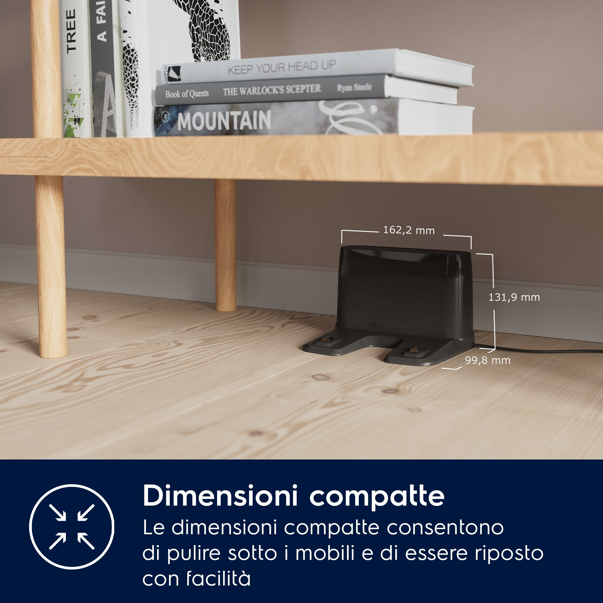 Ciemnoszare prostokątne urządzenie na drewnianej podłodze. Książki na półce nad nim. Pokazane wymiary.