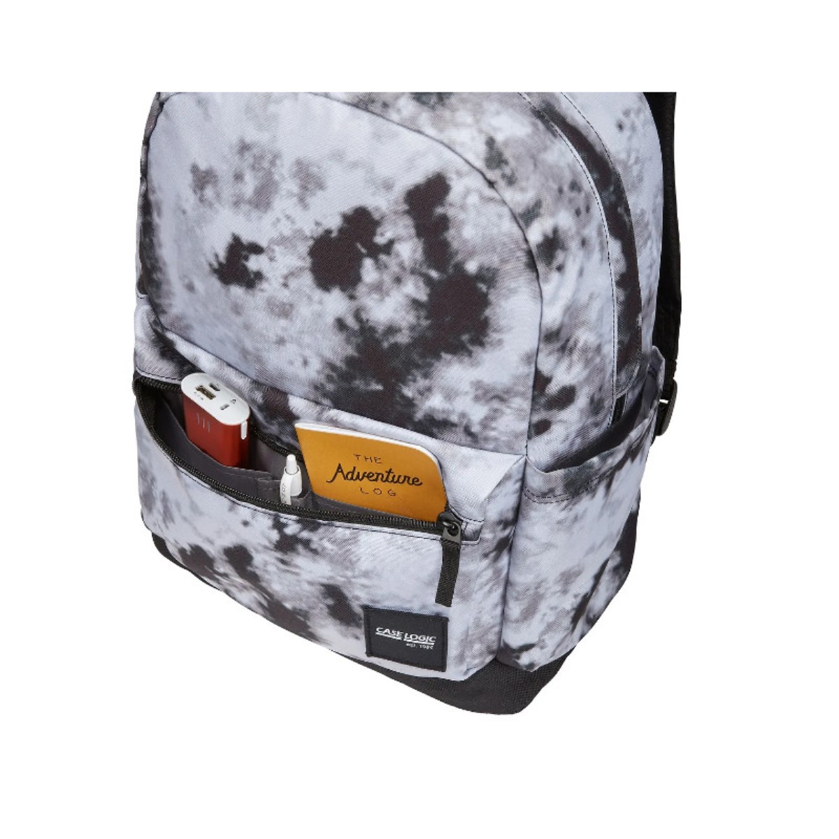 Ein Case Logic Rucksack mit Batikmuster. Ein Notizbuch, eine Powerbank und ein Stift befinden sich in der Vordertasche.