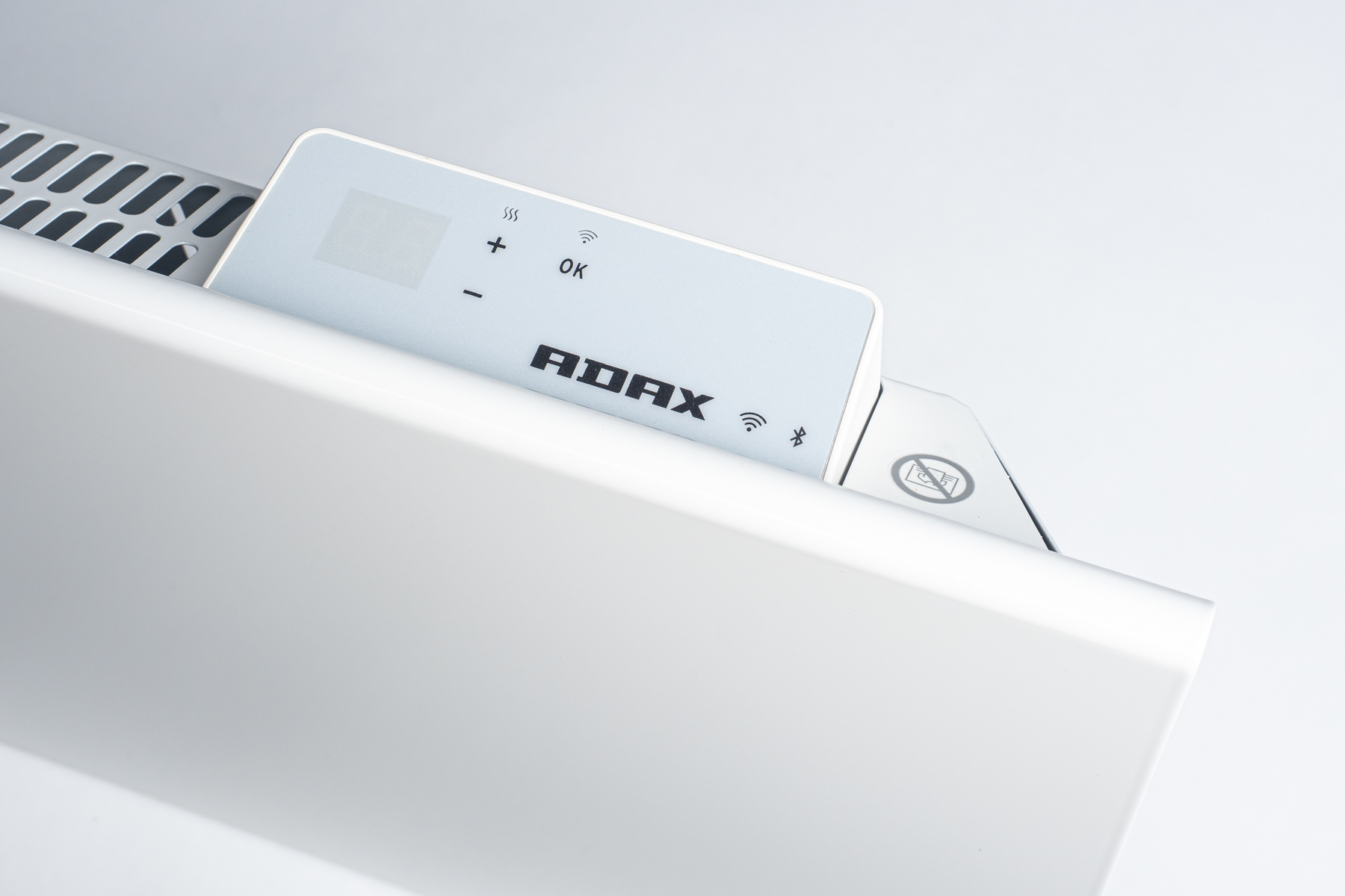 Un riscaldatore elettrico bianco con pannello di controllo. Il pannello mostra simboli e il logo ADAX. Il riscaldatore è su una superficie bianca.