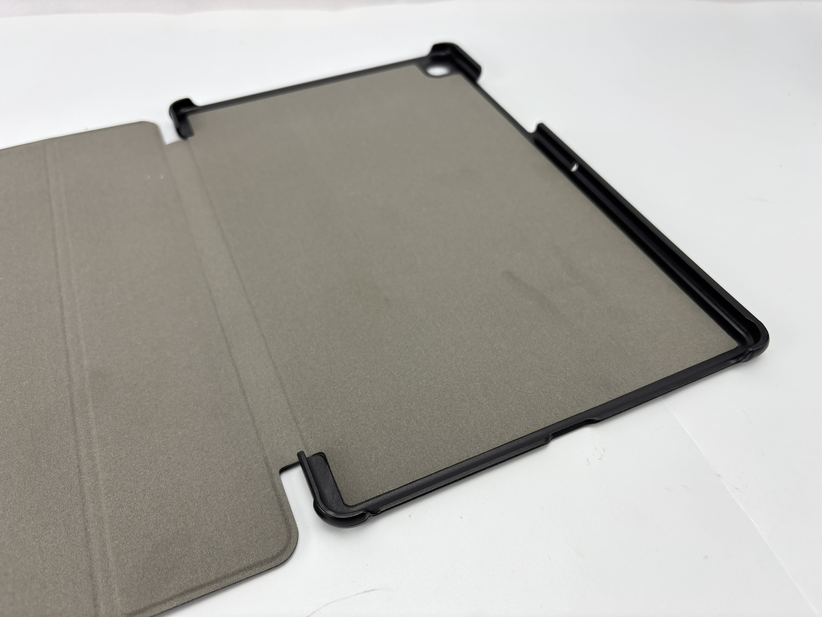 Open tablet case op wit. Case is grijs, met een zwarte rand. De cover is open.
