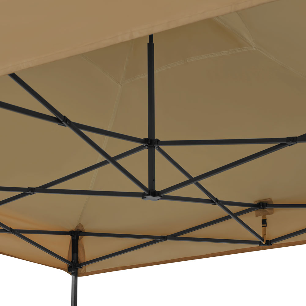 Zandkleurige luifel met zwart metalen frame. Het frame is een kruispatroon. Een riem hangt van de luifel.