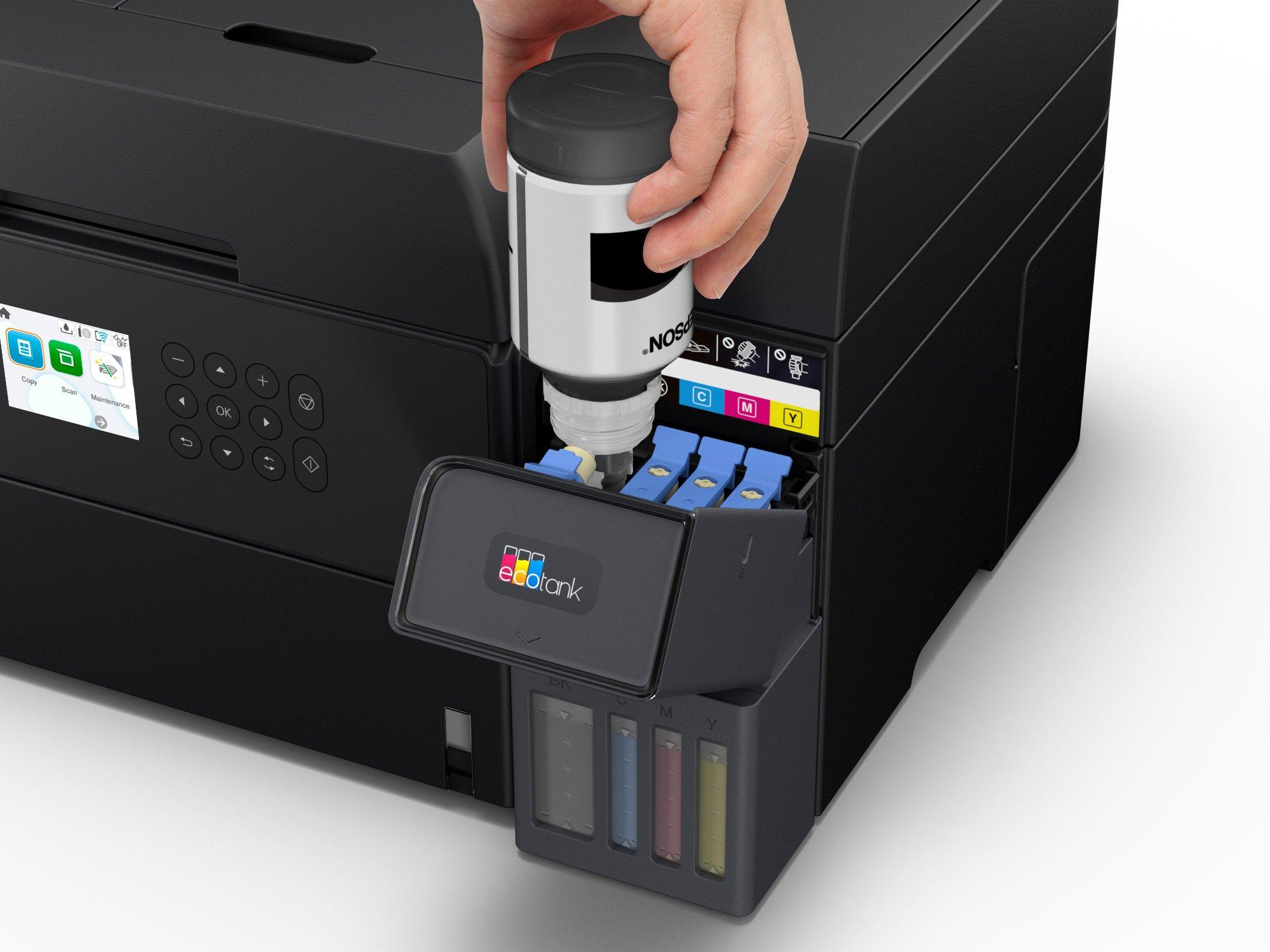 Una mano che riempie una stampante Epson con inchiostro. La stampante è nera e il flacone di inchiostro è bianco con dettagli neri.