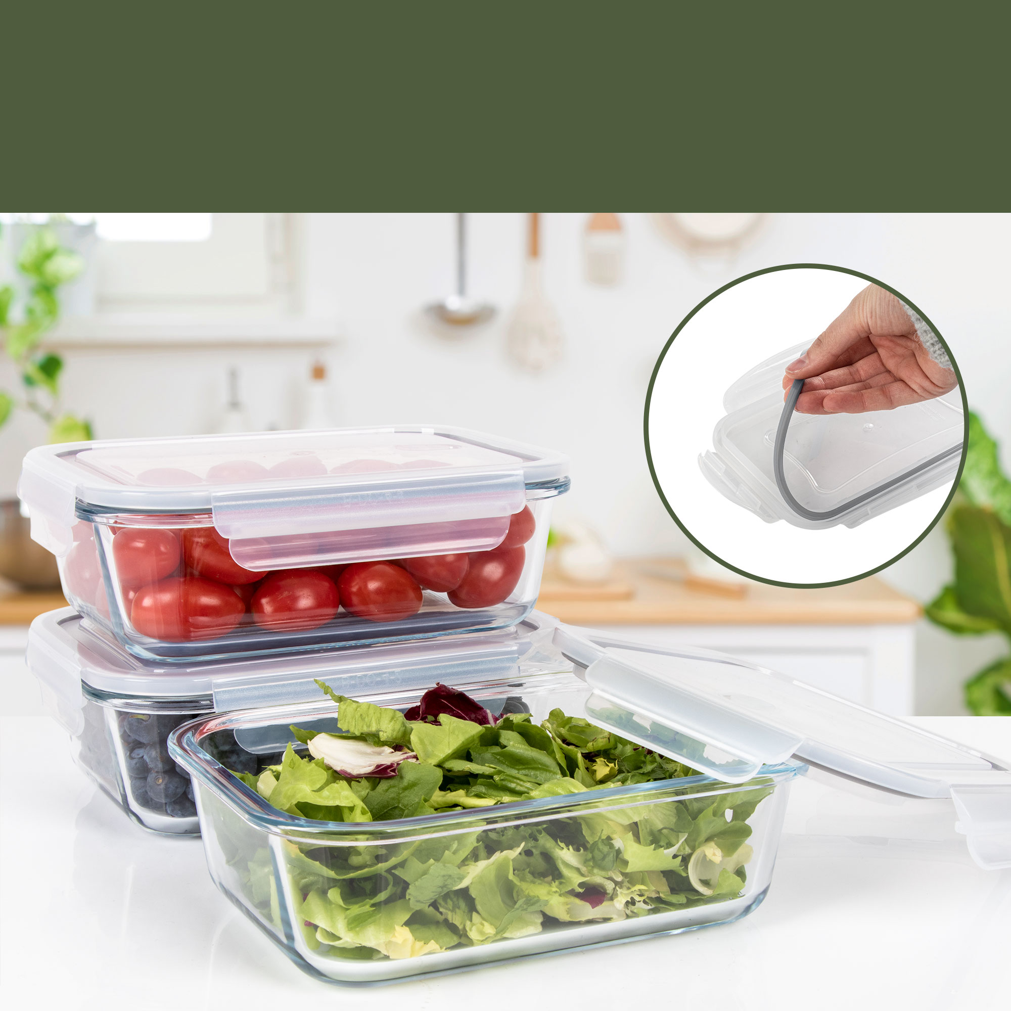 Szklane pojemniki na żywność z pomidorami, jagodami i sałatą. Ręka otwiera pokrywkę. Biała powierzchnia z rozmytym tłem kuchni.