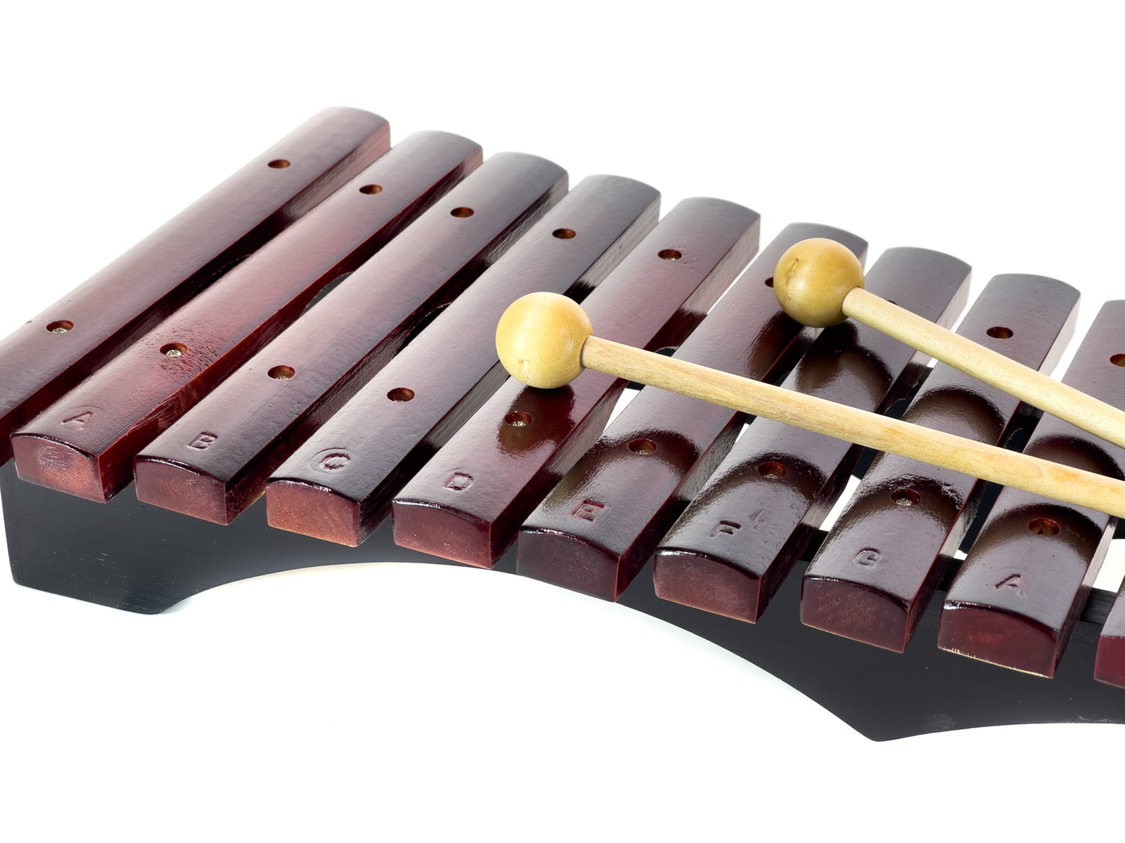 Ein Xylophon mit Holzstäben und Schlägeln. Die Stäbe sind dunkelbraun, die Schlägel haben Holzgriffe und runde Köpfe. Vor weißem Hintergrund.