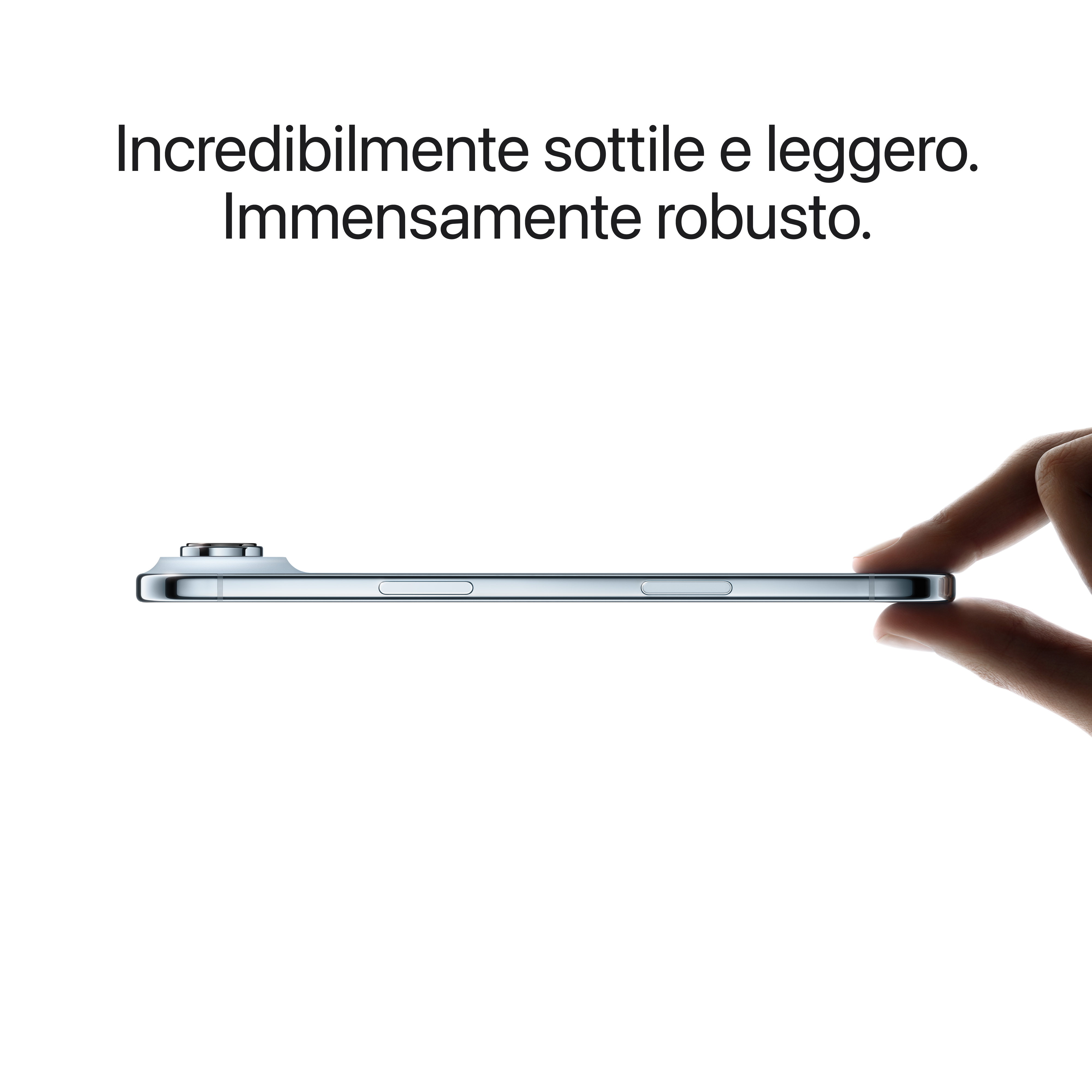 Profilo laterale di un telefono, tenuto in mano. È sottile e argentato, con pulsanti e una fotocamera su sfondo bianco.