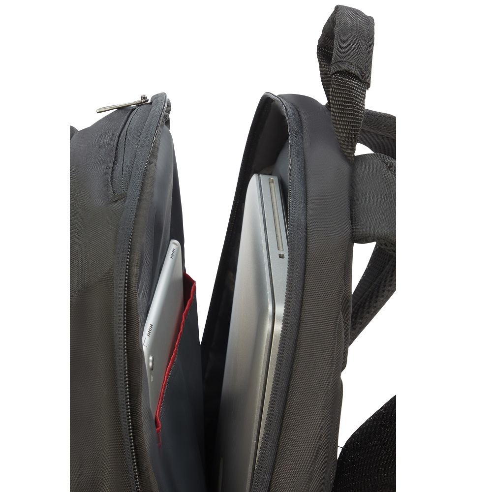 Zaino nero aperto, che rivela un laptop e un tablet argentati. Tasca rossa all'interno. Cerniera e maniglia visibili.