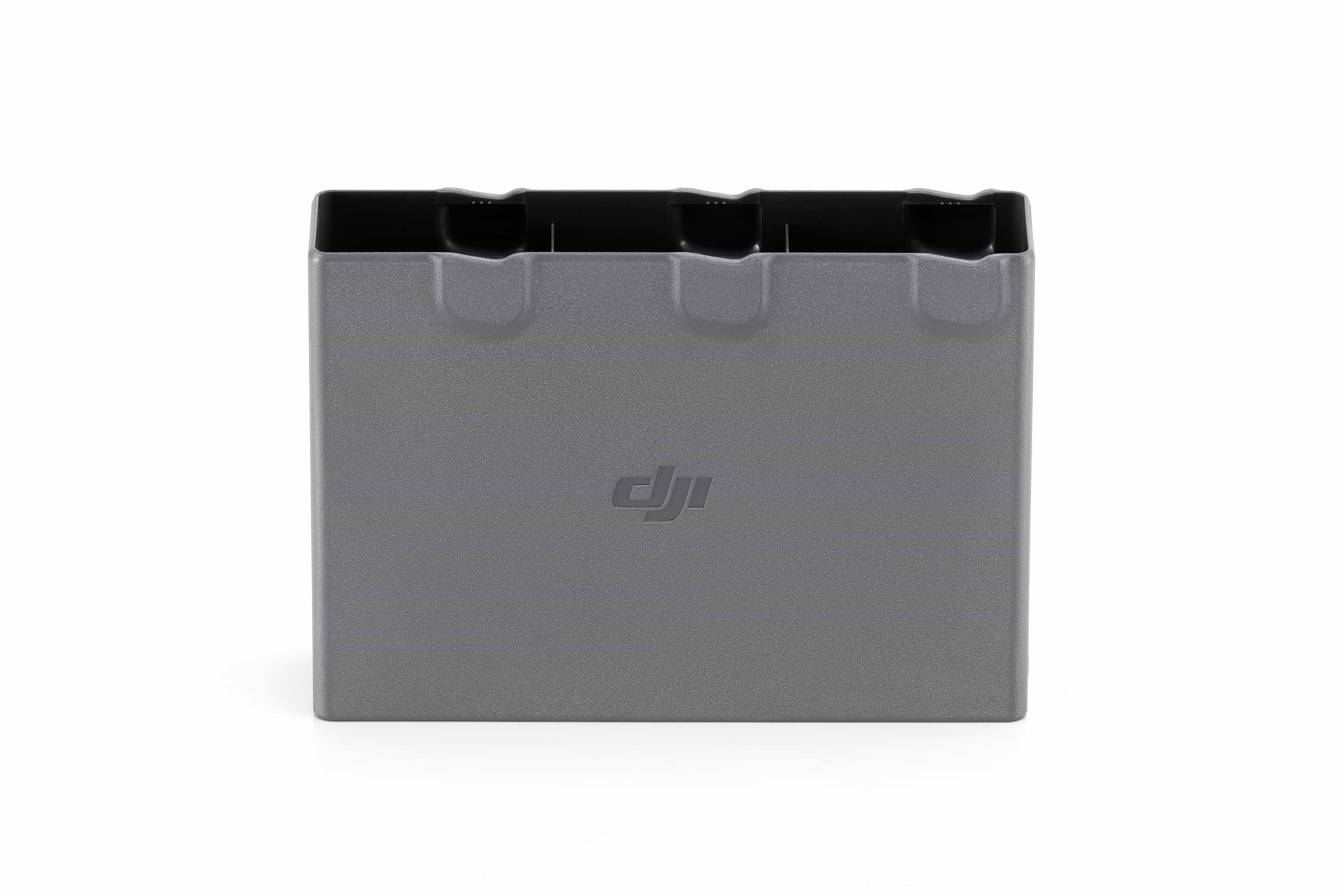Custodia di ricarica batteria DJI grigia. Ha un coperchio nero con tre slot per la ricarica. Sfondo bianco.