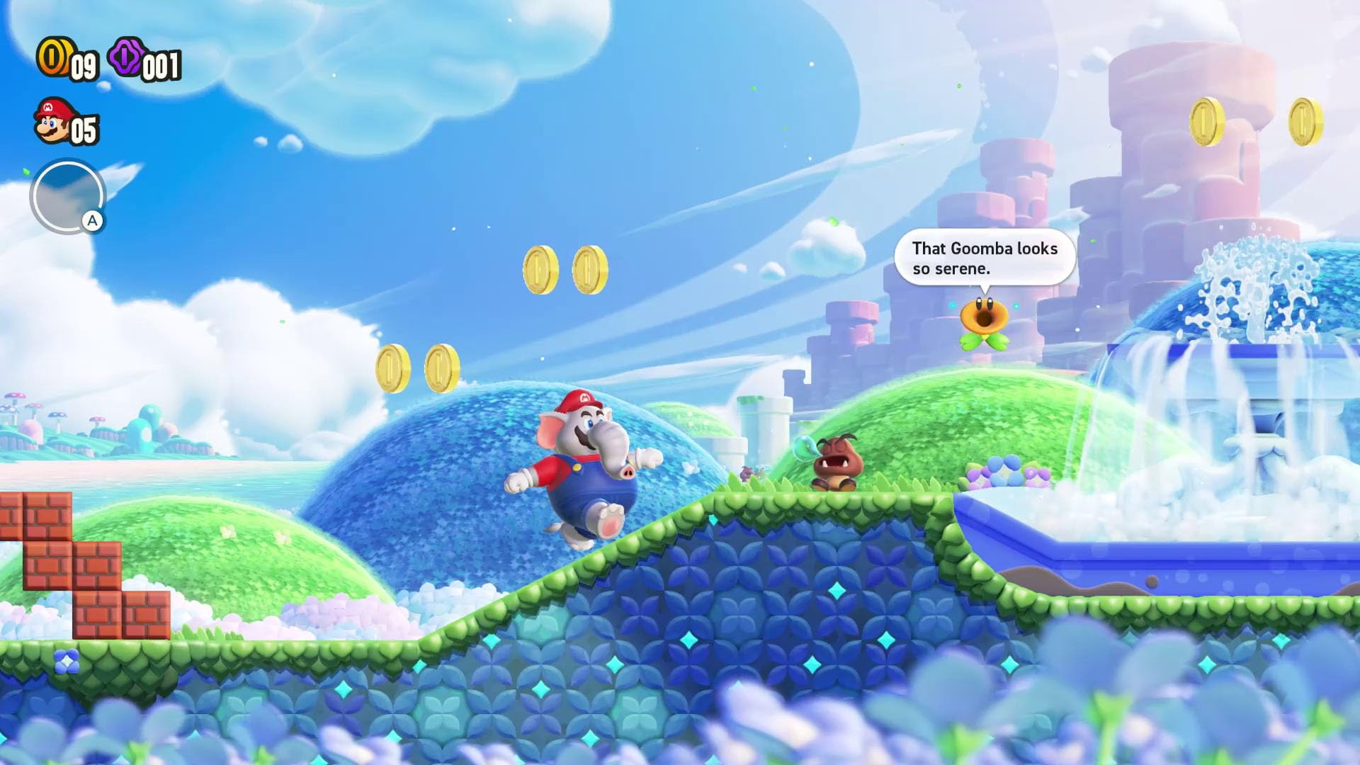 Un personaje tipo Mario con cabeza de elefante salta. Monedas flotan. Un Goomba y una fuente en el fondo. Paisaje azul y verde.