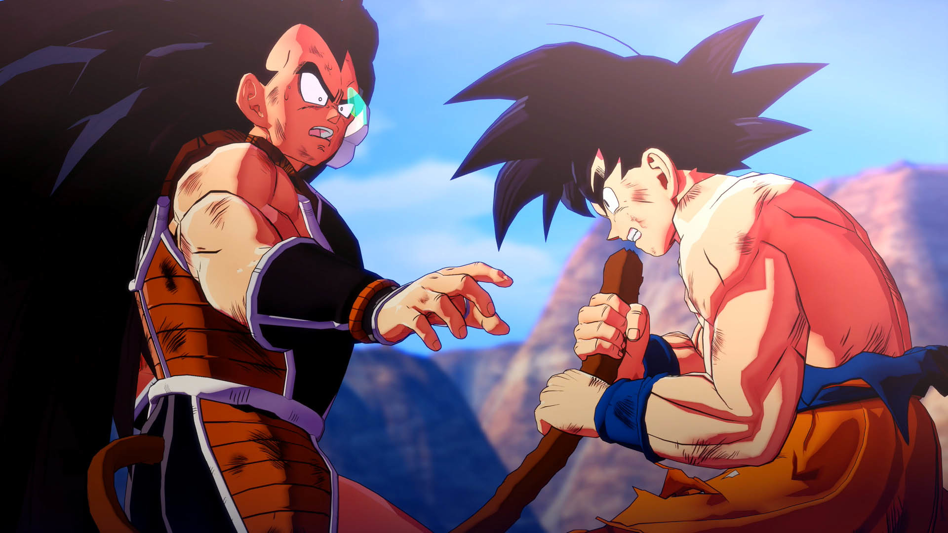 Due personaggi di Dragon Ball si affrontano. Uno indica, l'altro tiene un bastone. Montagne e cielo blu sullo sfondo.
