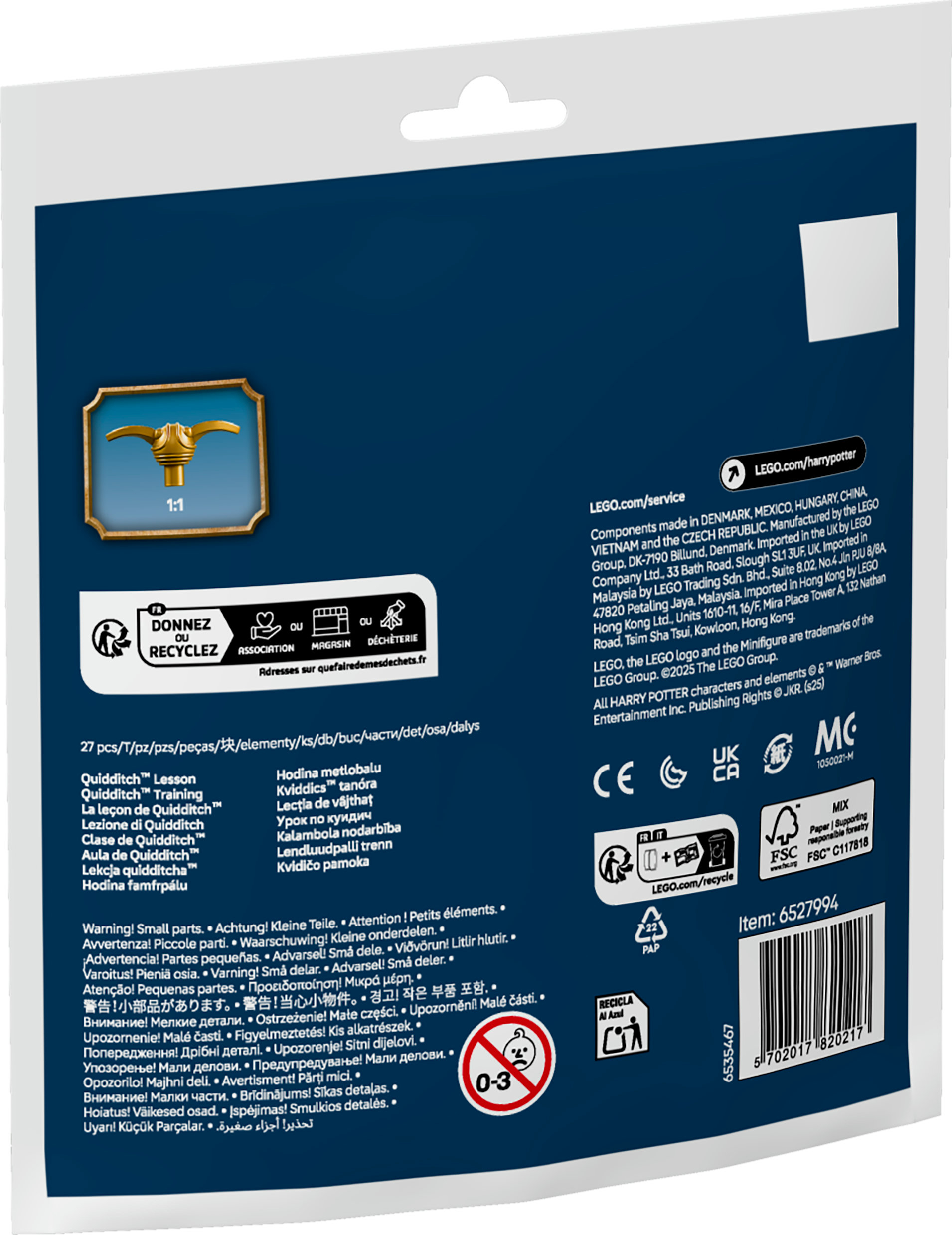Pudełko produktu pokazuje złote trofeum, tekst i ostrzeżenia przed małymi elementami. Tło jest ciemnoniebieskie.