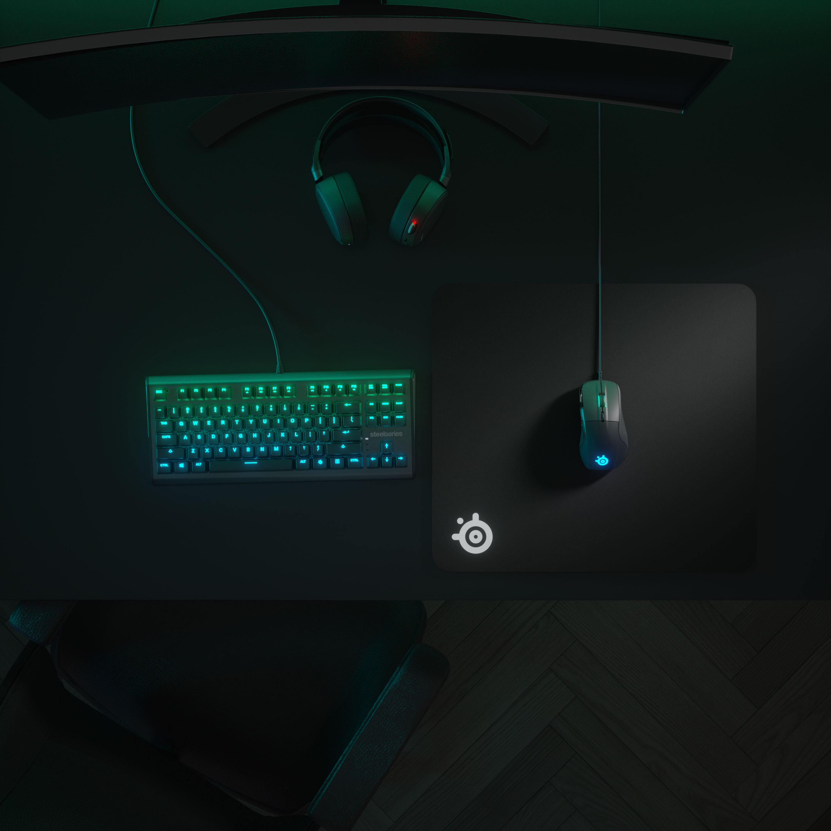A gaming setup with keyboard, mouse, headphones, and monitor. All lit up with a green-blue glow.