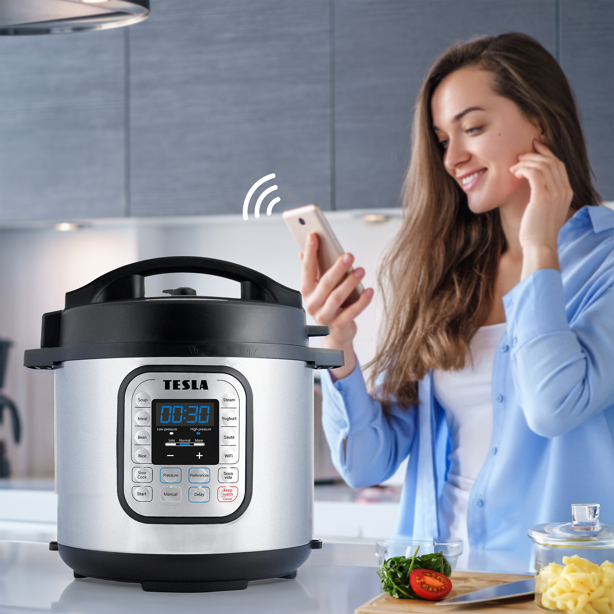 Donna in cucina usa il telefono vicino a una pentola a pressione. Verdure su un tagliere. Segnale wireless.