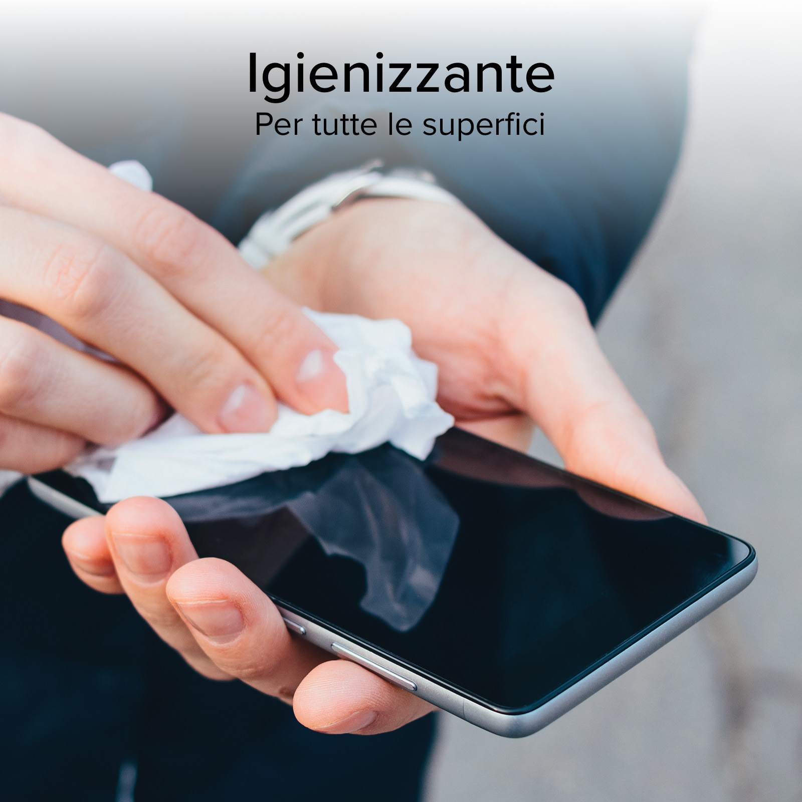 Una persona sta pulendo lo schermo di uno smartphone con una salvietta bianca. Il telefono è nero e ha una cornice argentata.