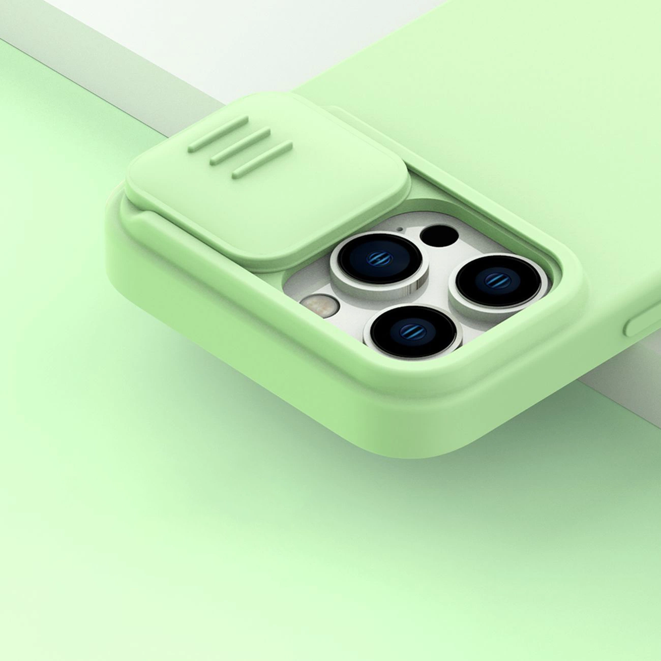 Primo piano di una custodia per telefono verde chiaro con un ritaglio per la fotocamera. Il ritaglio rivela tre lenti e un flash. La custodia ha una copertura scorrevole.
