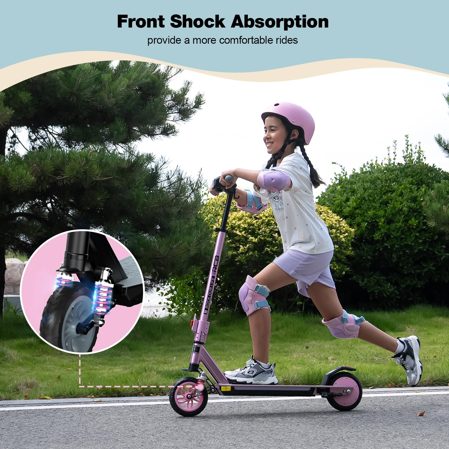 Une fille avec un casque et des coussinets monte un scooter rose sur un chemin pavé. Le texte d'absorption des chocs avant est visible.