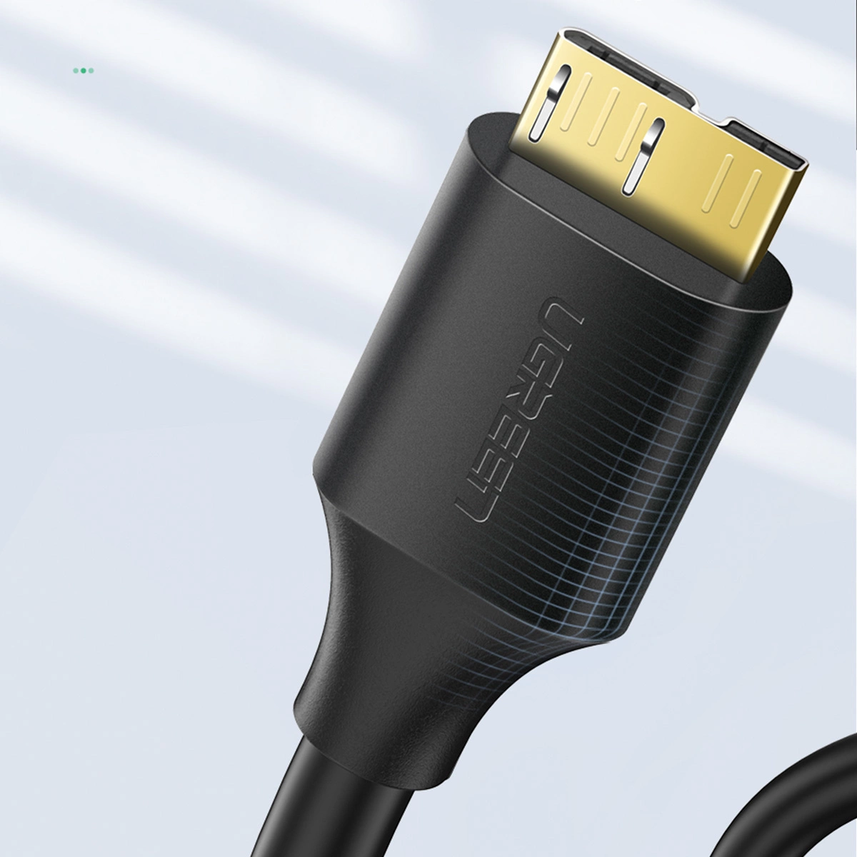 Close-up van een zwarte HDMI-kabel met een goudkleurige connector. De kabel heeft de merknaam UGREEN erop.