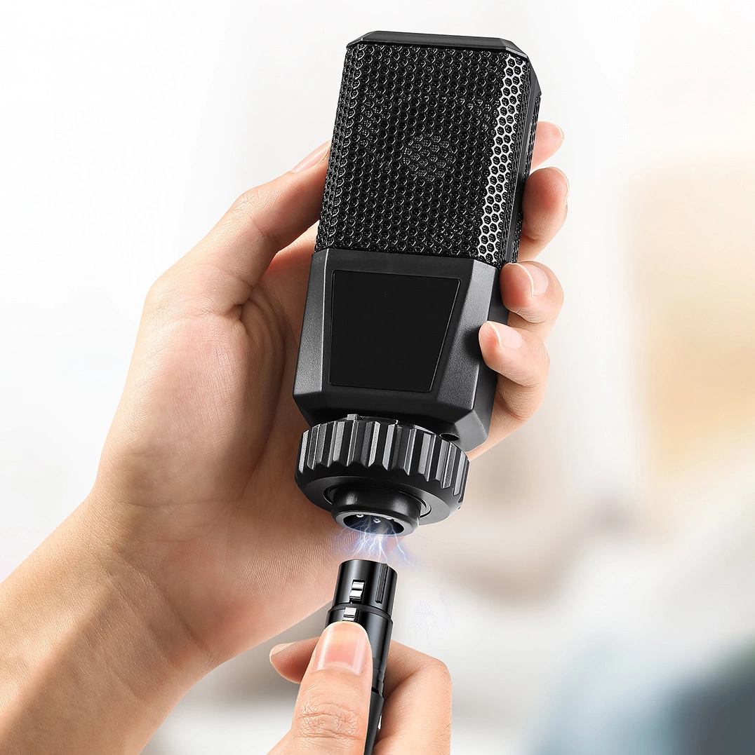 Osoba trzyma czarny mikrofon i złącze XLR. Złącze jest podłączane do mikrofonu.