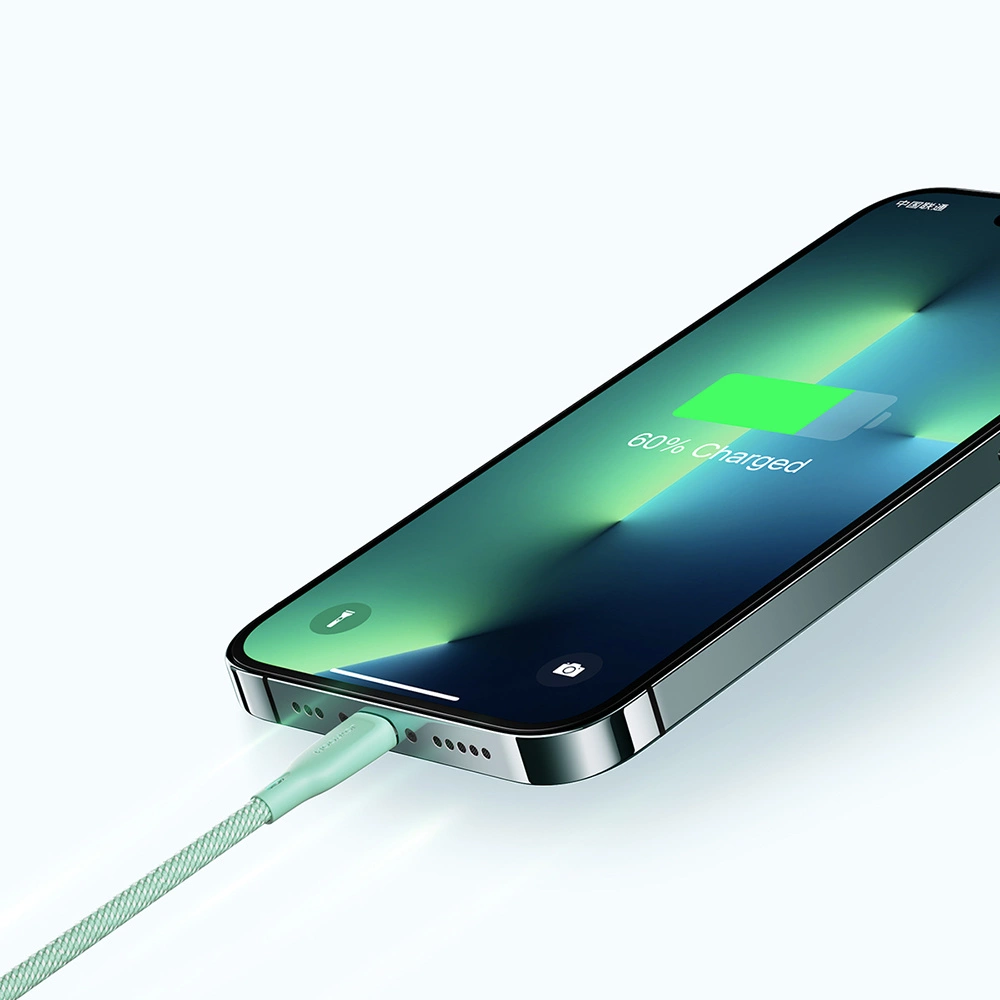 Un iPhone è in carica. Lo schermo mostra il 60% di carica. Un cavo verde chiaro è collegato.