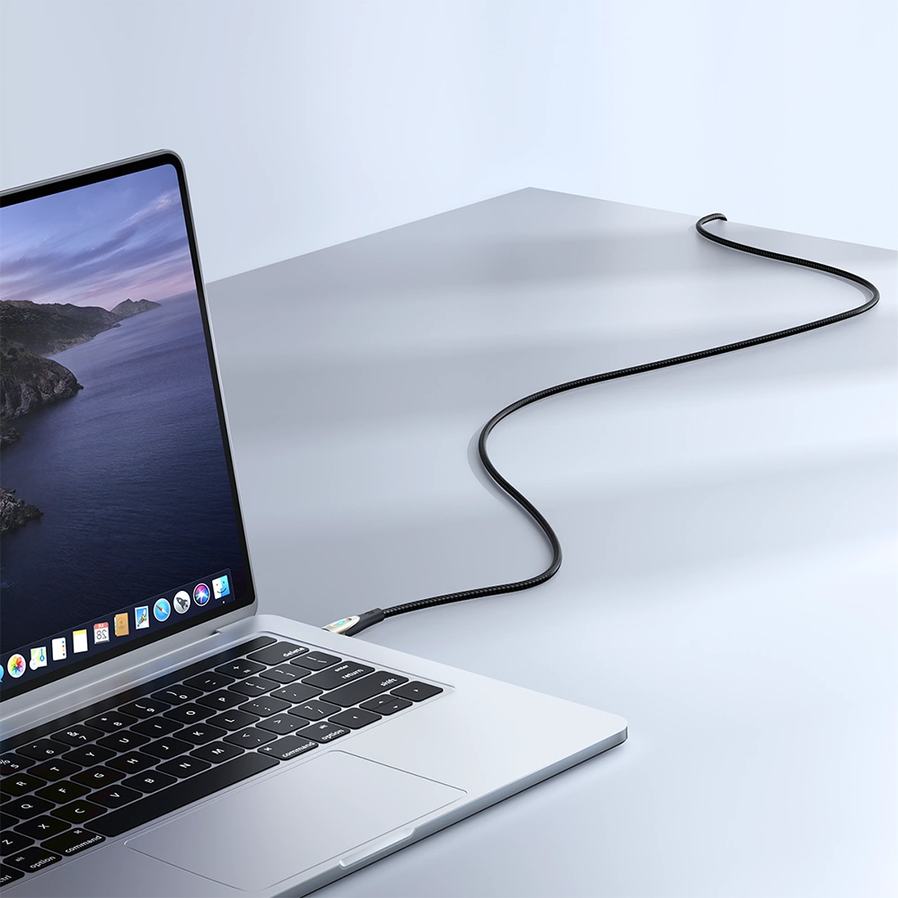Ein Laptop mit einem schwarzen Kabel. Der Bildschirm zeigt Symbole. Der Laptop steht auf einer weißen Oberfläche.