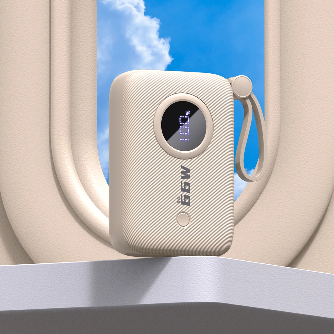 Un power bank beige con uno schermo che mostra il 100%. Ha un cinturino. Cielo blu e sfondo beige.