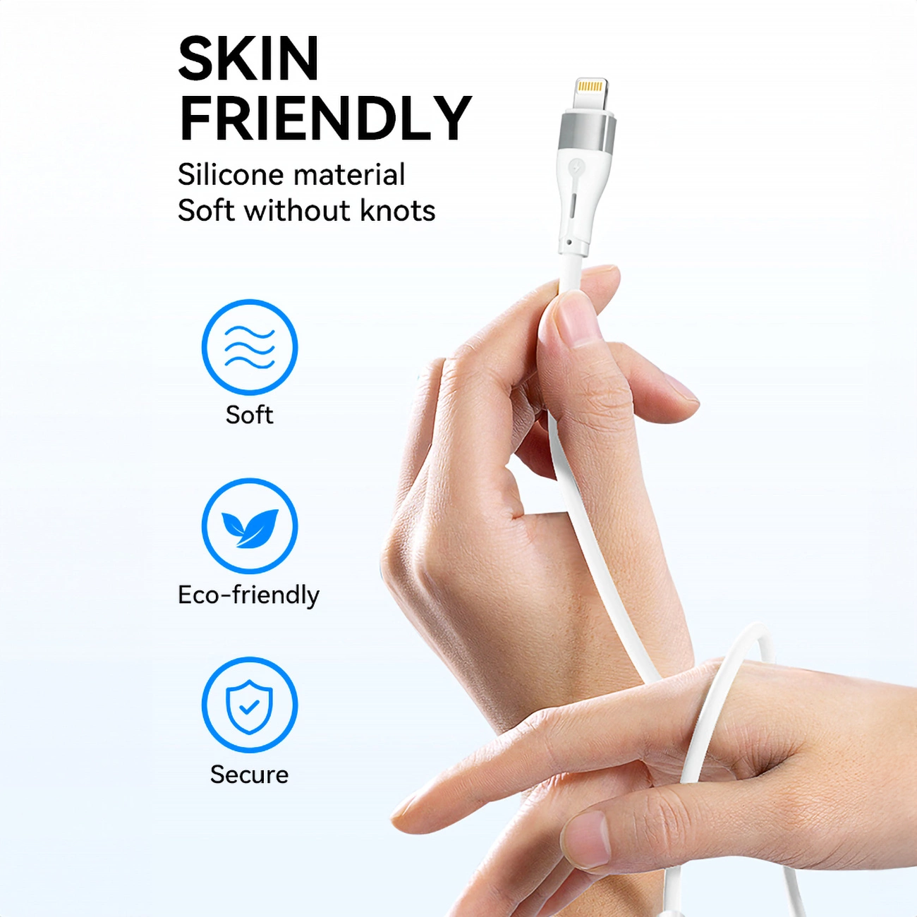 Dłoń trzyma biały kabel ładujący ze srebrnym złączem. Tekst mówi 'Skin Friendly', 'Materiał silikonowy' i ikony dla 'Miękkie', 'Ekologiczne' i 'Bezpieczne'.