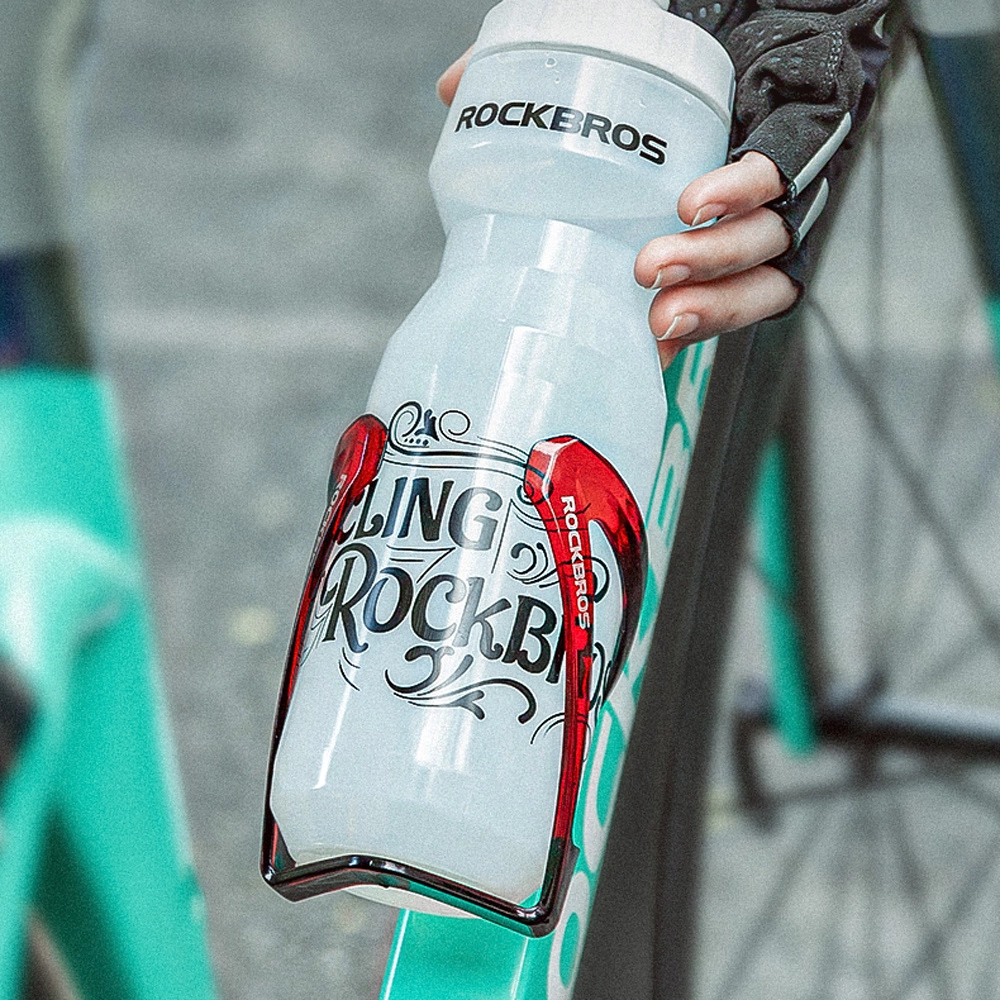 Eine Person hält eine Rockbros-Wasserflasche. Die Flasche ist weiß mit roten Akzenten und dem Rockbros-Logo. Im Hintergrund ist ein Fahrrad.